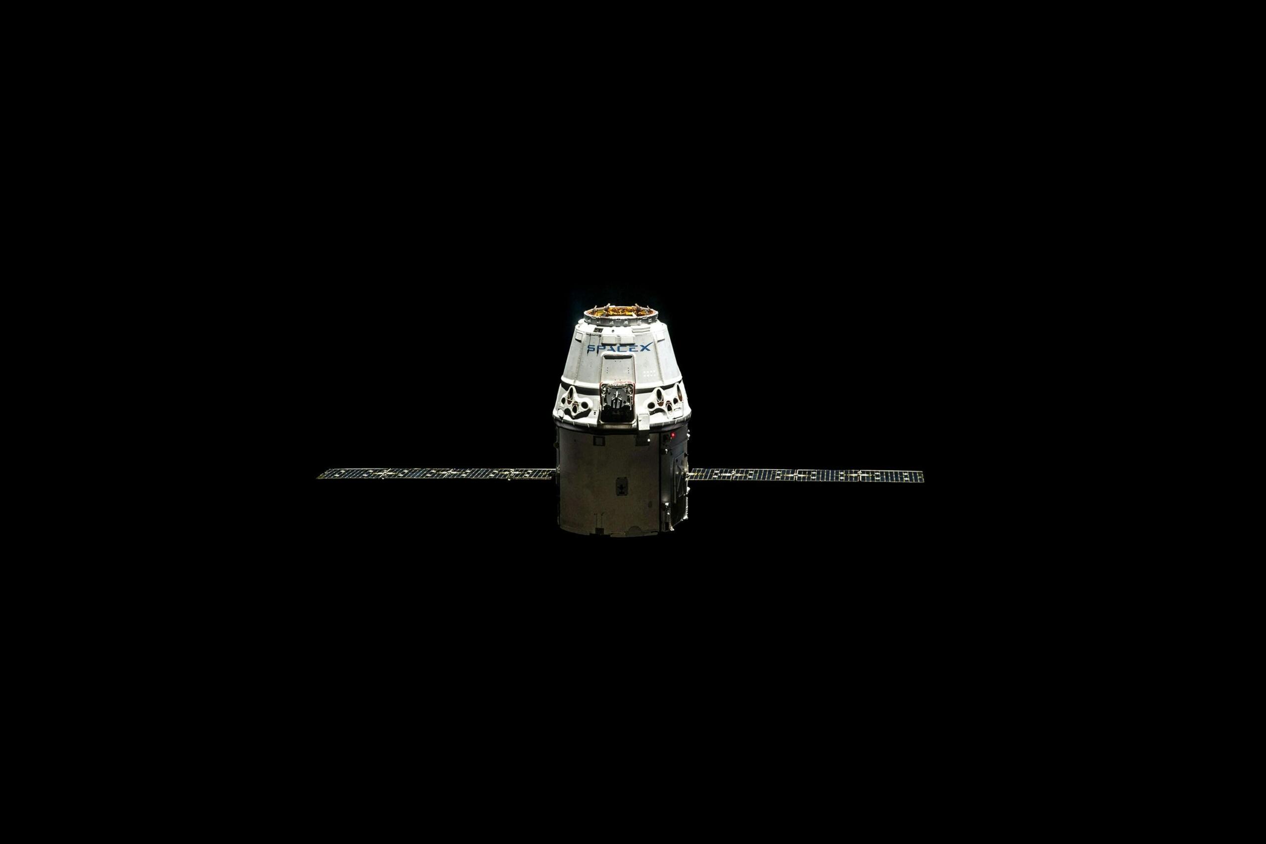 Ruimtecapsule van SpaceX (Dragon) tegen zwarte achtergrond.