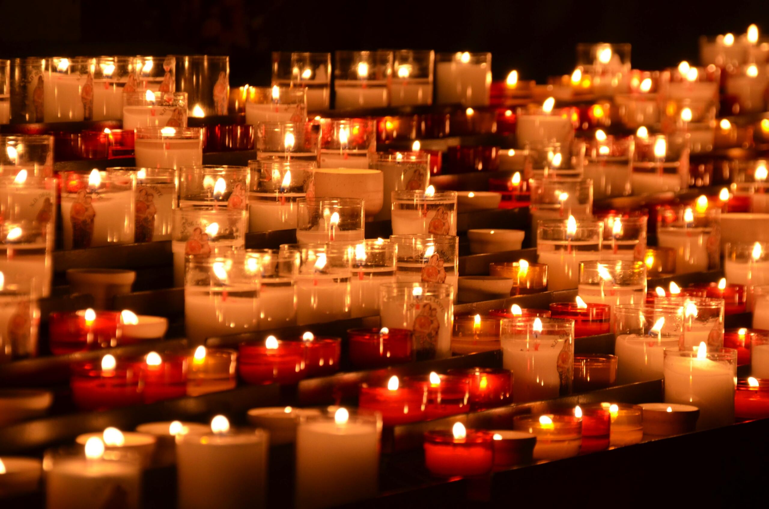 Honderden kaarsjes branden in glazen houders tijdens een boeddhistische ceremonie.