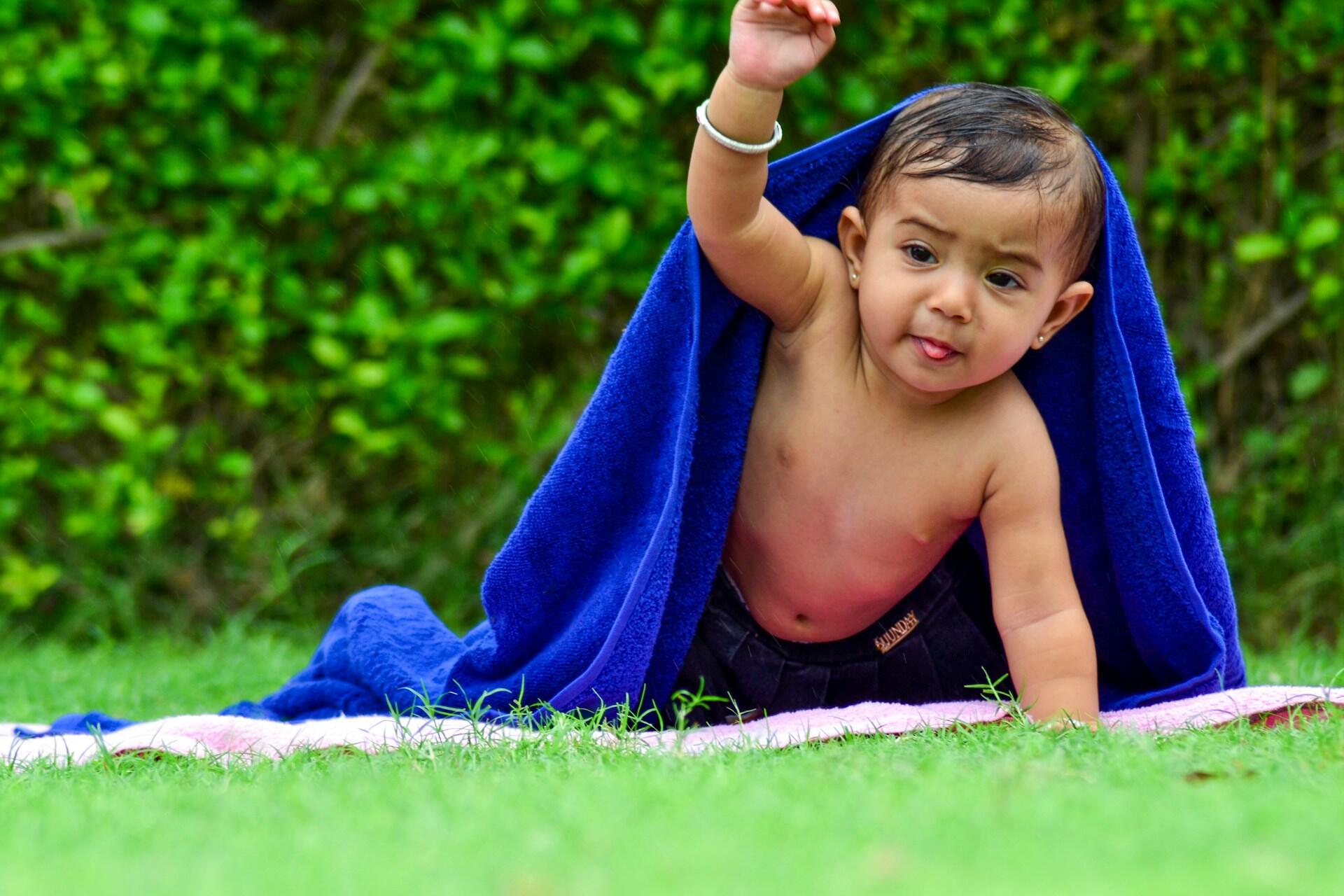 Baby leunt op de ene arm en houdt de andere omhoog
