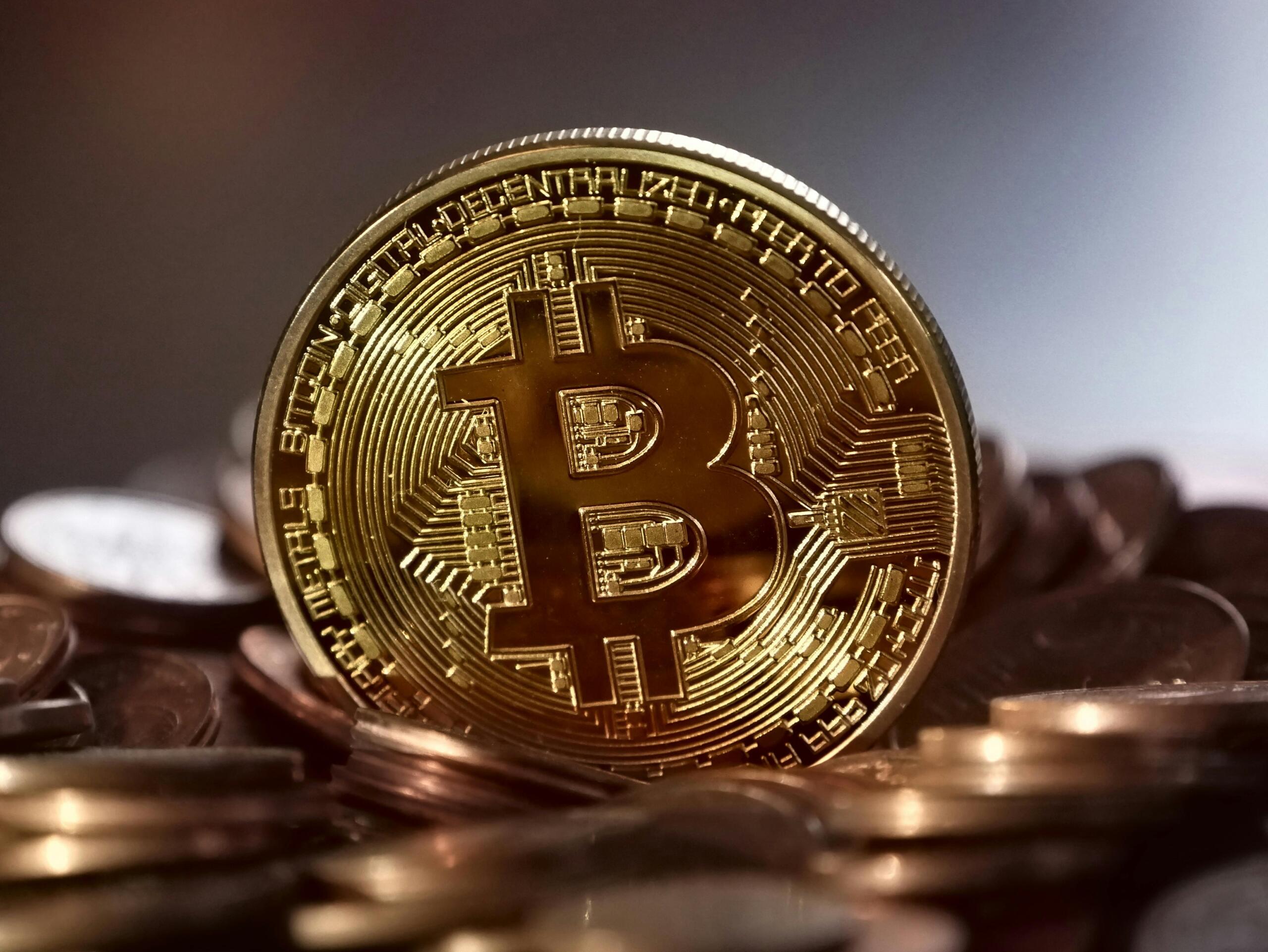 Een gouden bitcoin-munt tussen munten, als metafoor voor digitale valuta.