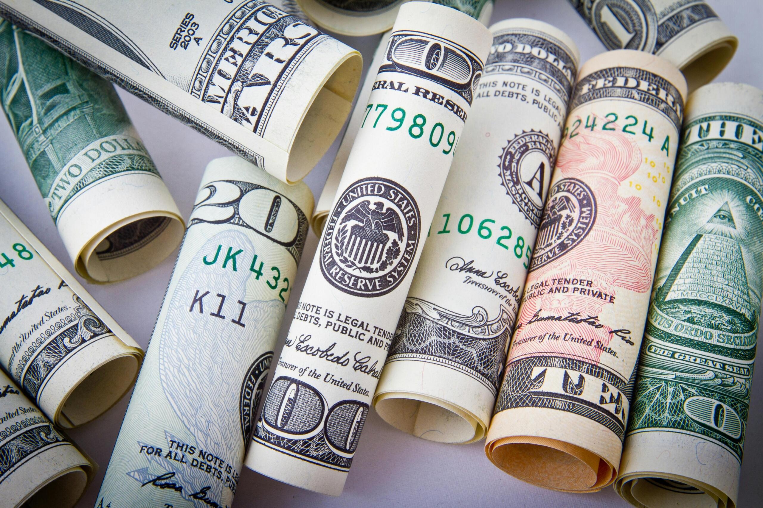 Opgerolde Amerikaanse dollarbiljetten symbool voor fiatgeld.