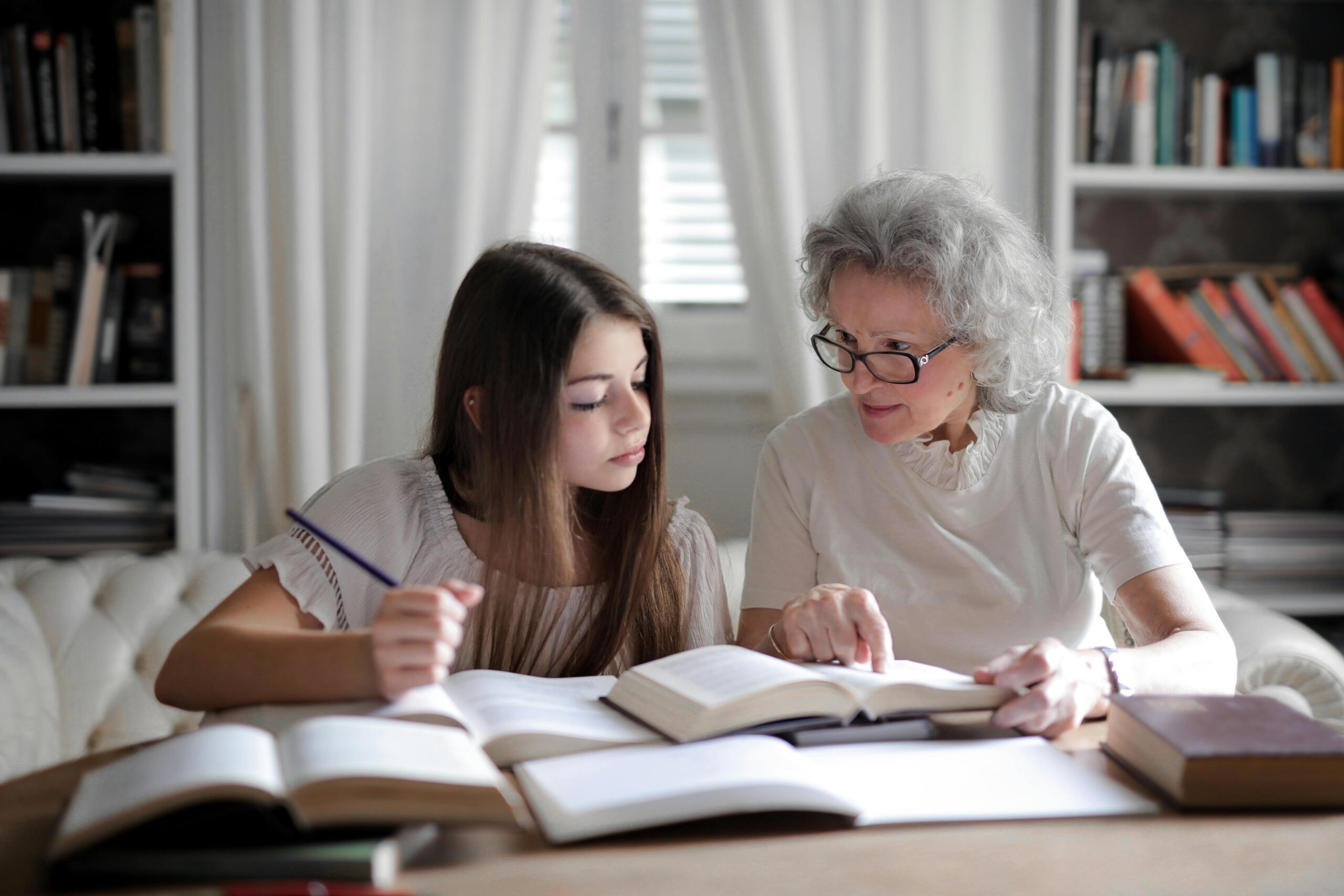 Een vrouw geeft een kind bijles in een ruimte vol boeken