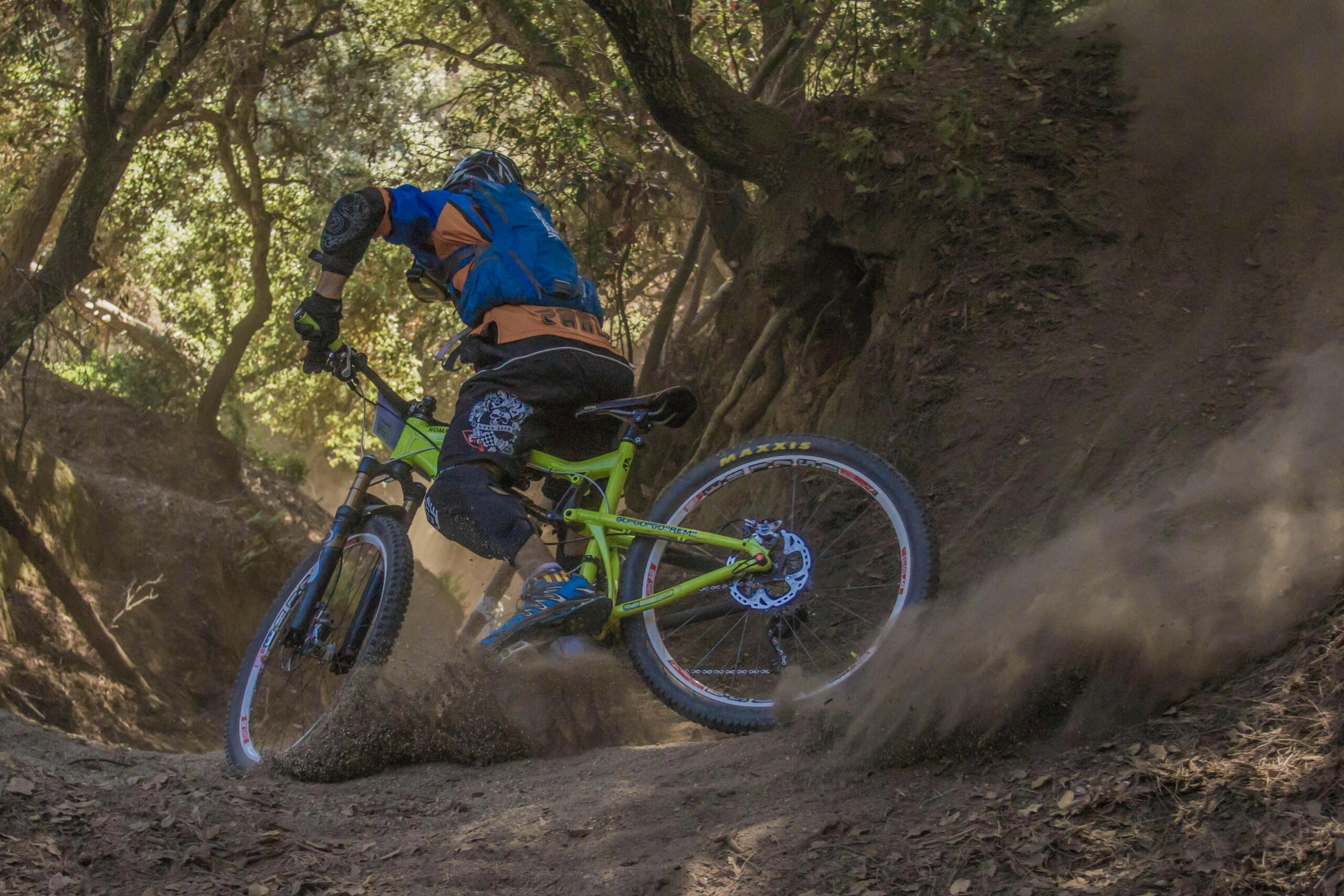 Een mountainbiker scheurt door een stoffig bospaadje.