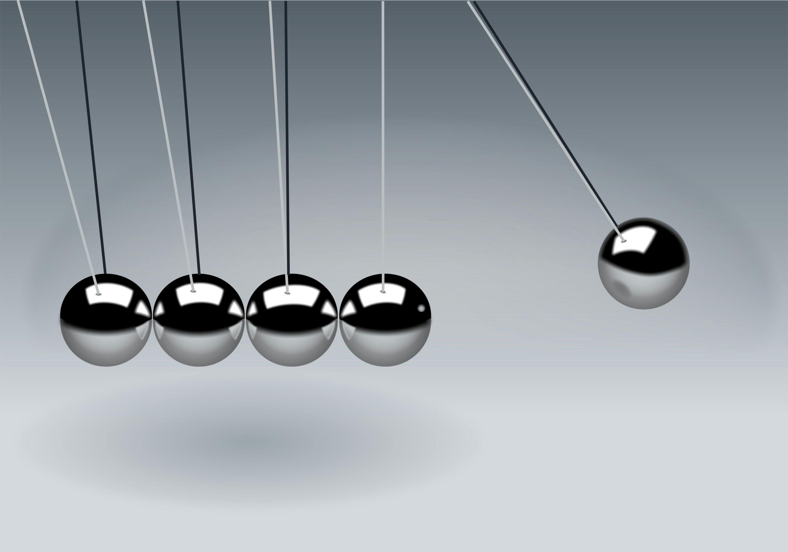 Newton’s cradle met metalen bollen die energieoverdracht demonstreren.
