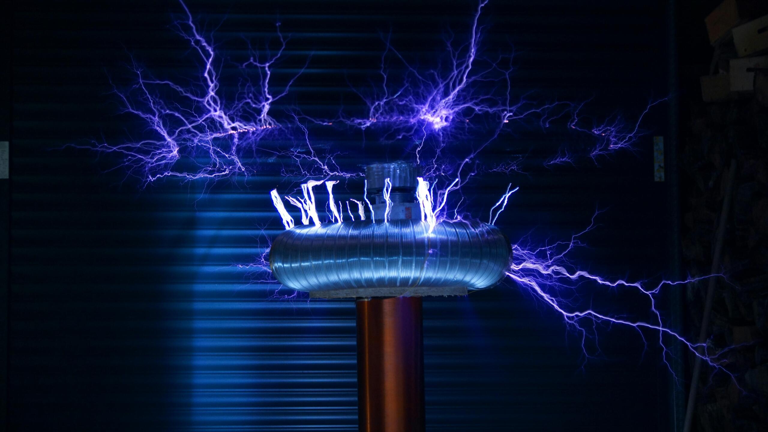 Foto van een Tesla-coil die elektrische ontladingen produceert in de vorm van blauwe bliksemflitsen.