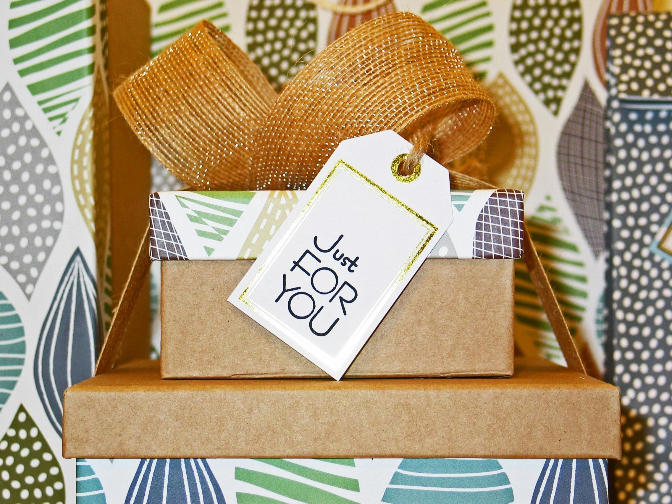 Stapel cadeauverpakkingen met decoratief papier en een label waarop “Just for you” staat.
