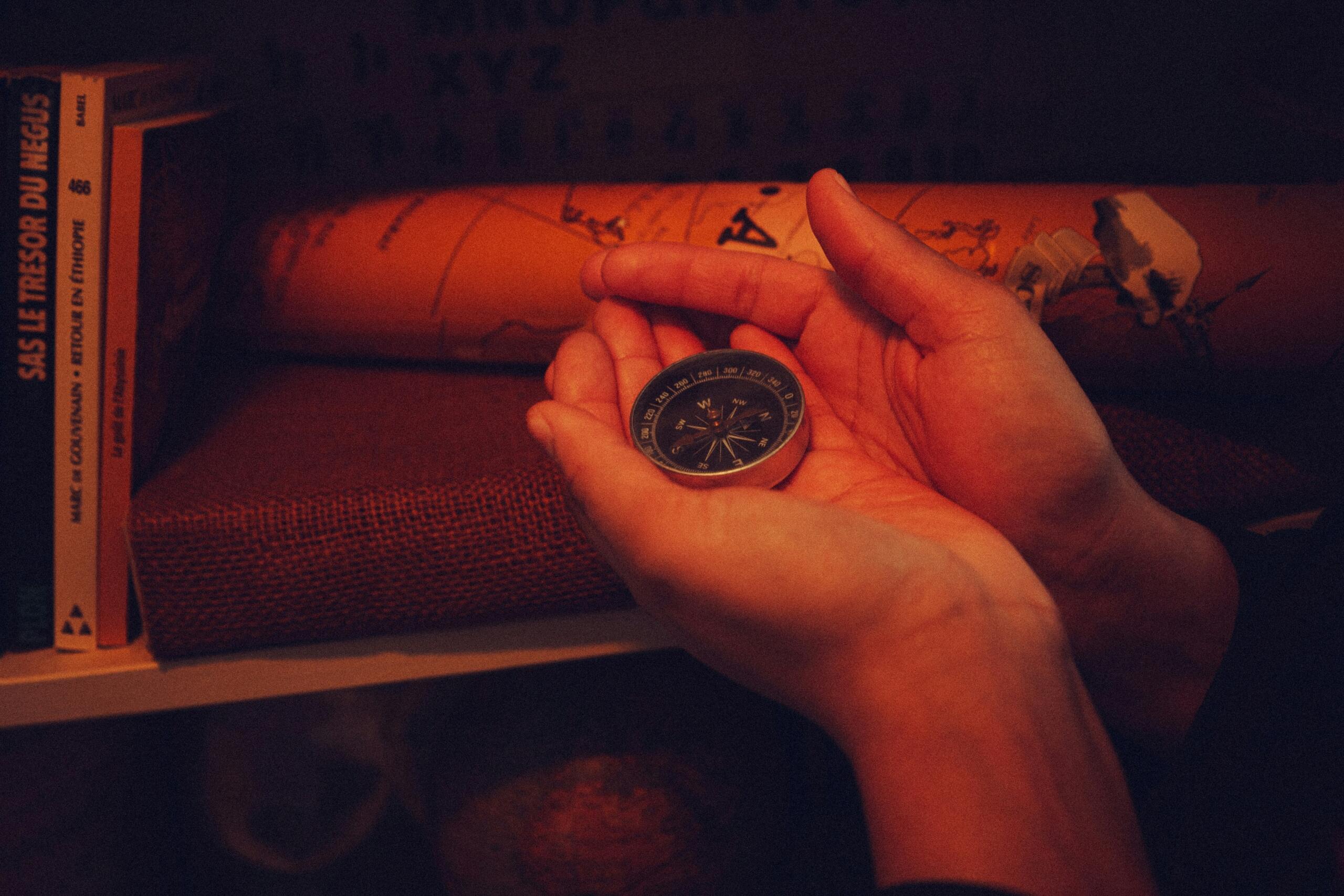 Een persoon houdt een kompas in de hand.