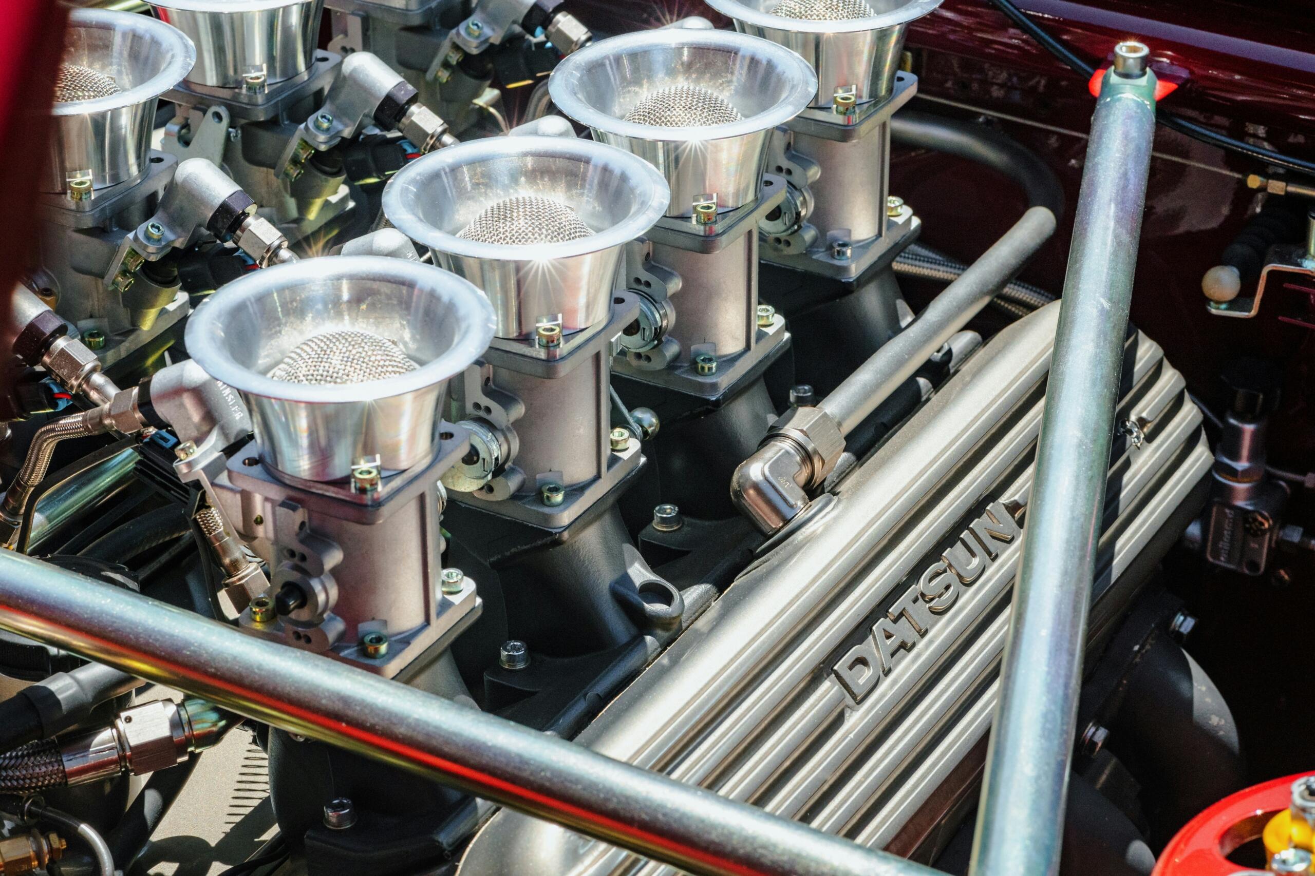 Close-up van een motorcompartiment met metalen onderdelen, bedrading en spoelachtige structuren.