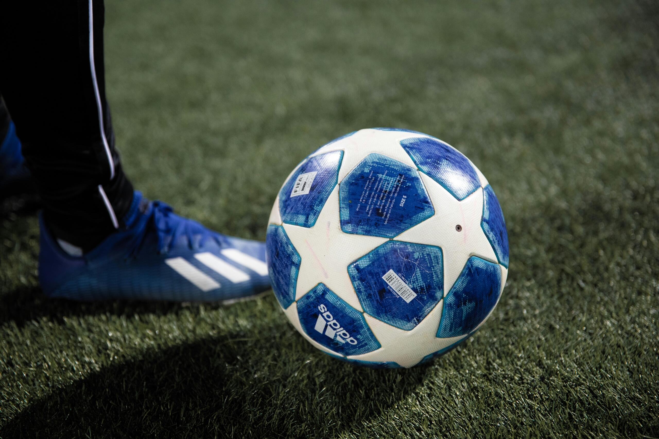 Een blauw-witte voetbal ligt op een groen grasveld.