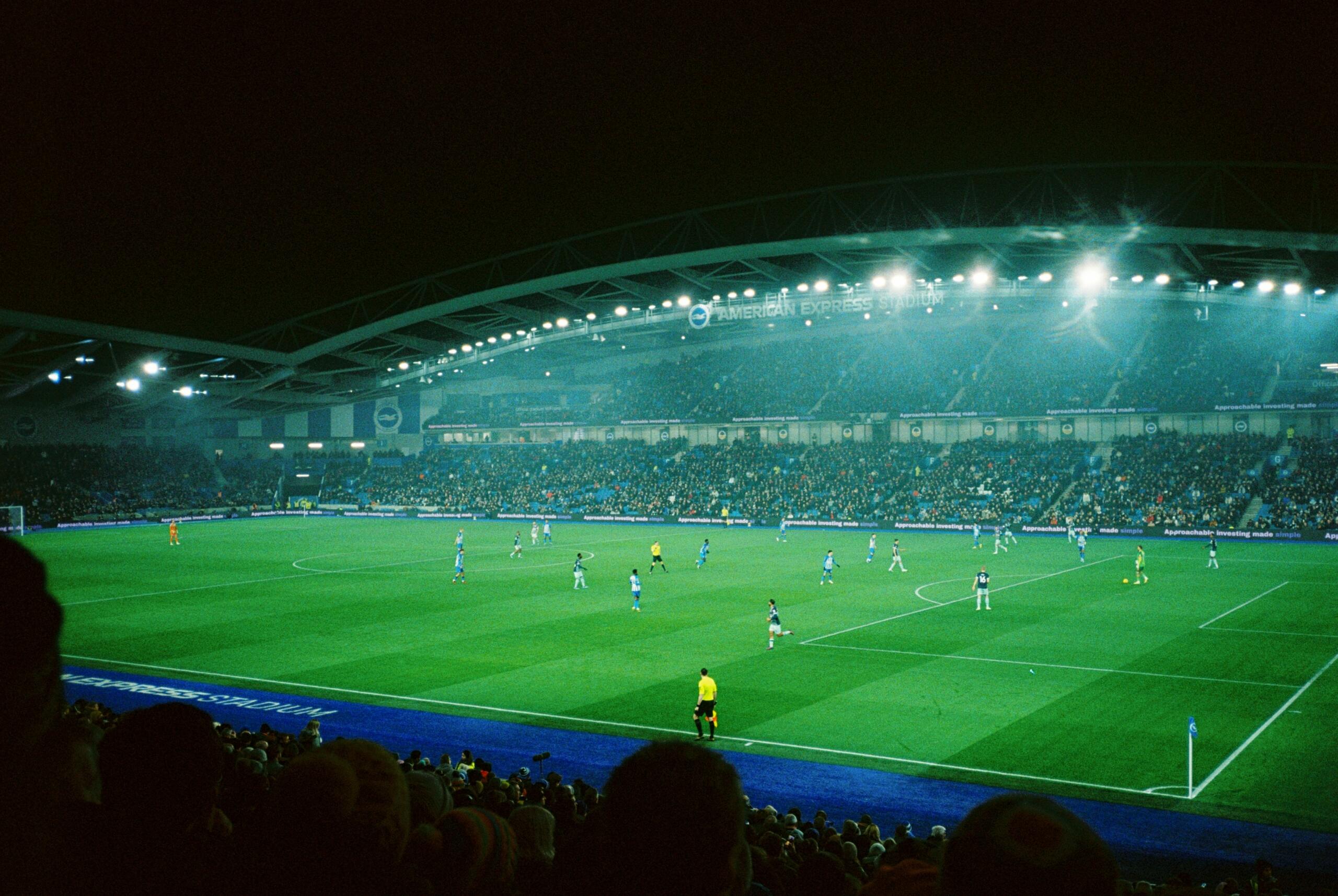 Een voetbalwedstrijd wordt gespeeld in een stadion bij nacht.