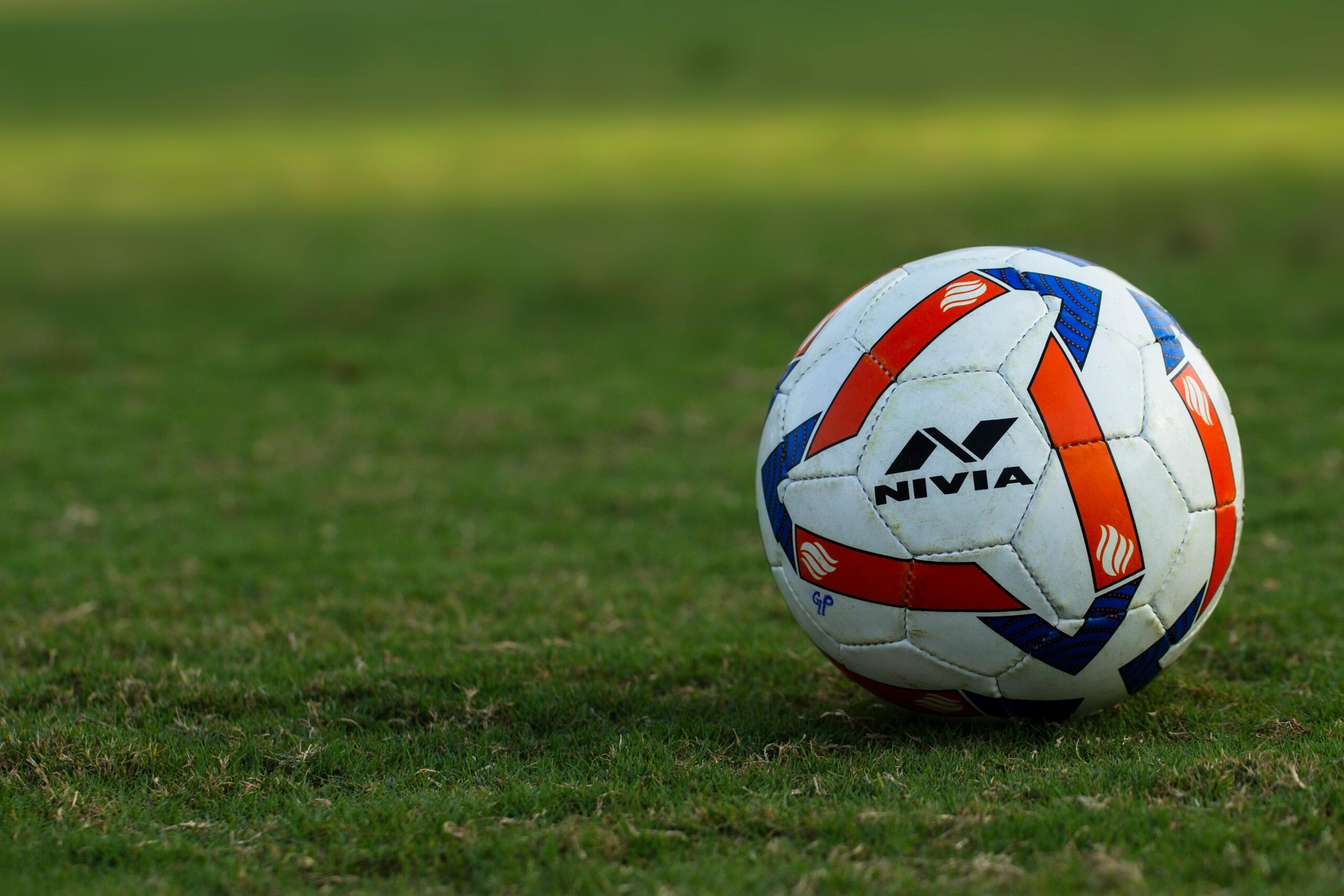 Een voetbal ligt op groen gras.