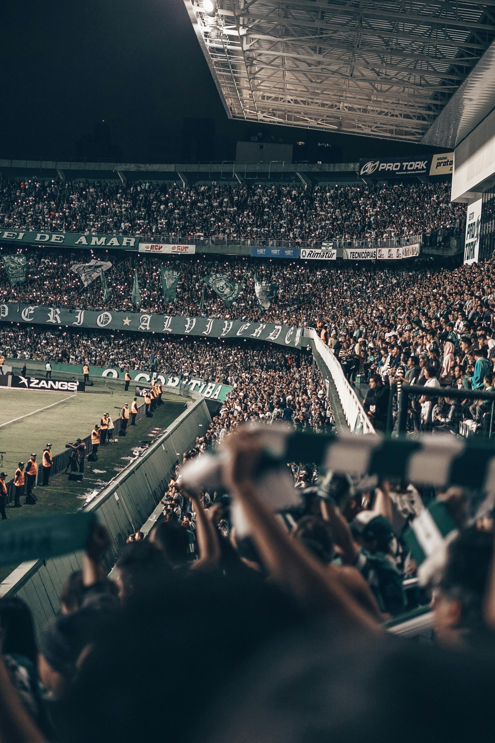 Mensen zitten in een stadion bij nacht.