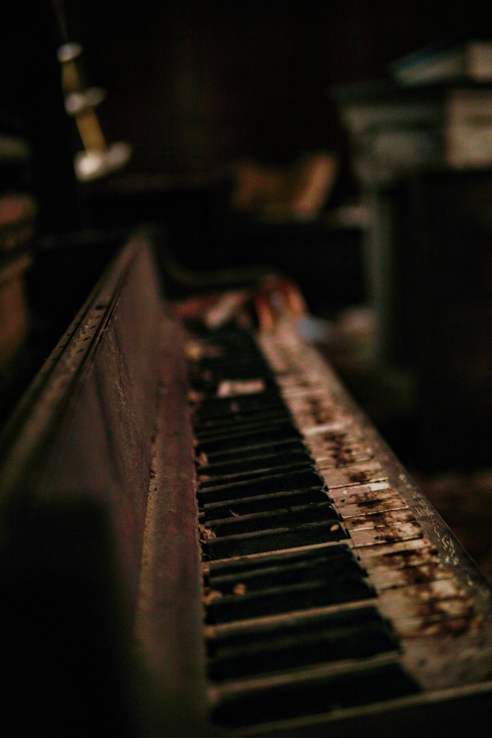 Close-up van een upright piano, met de toetsen en het kastontwerp duidelijk in beeld.