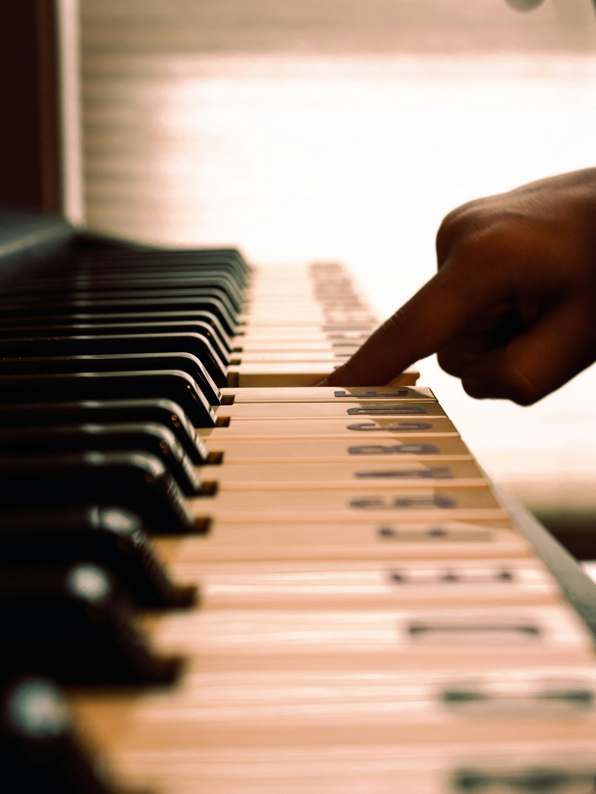 Een leerling speelt piano met letters op de toetsen.