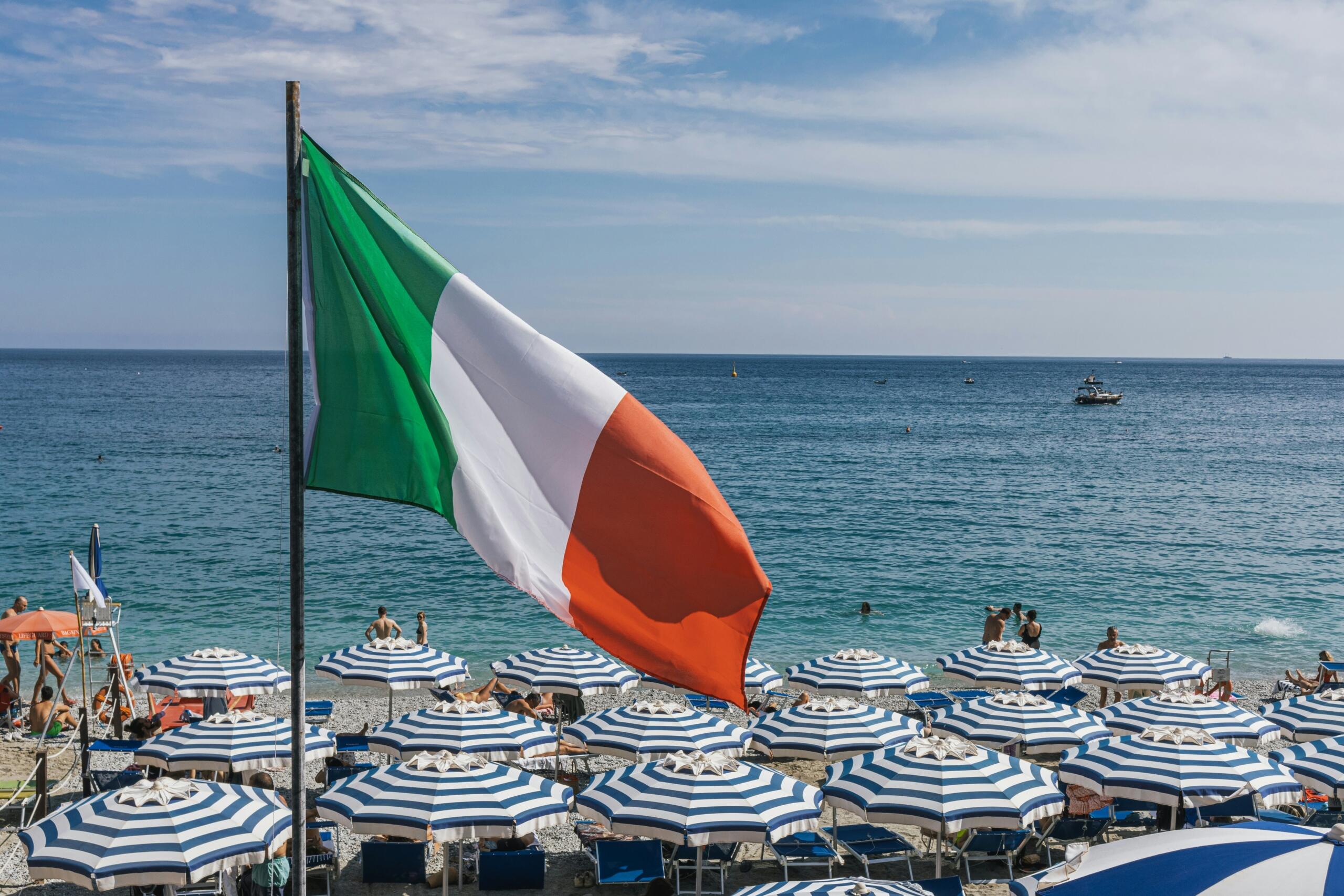 Italiaanse vlag aan een strand met uitzicht op zee | Bron: Pedro Pereira, via Unsplash