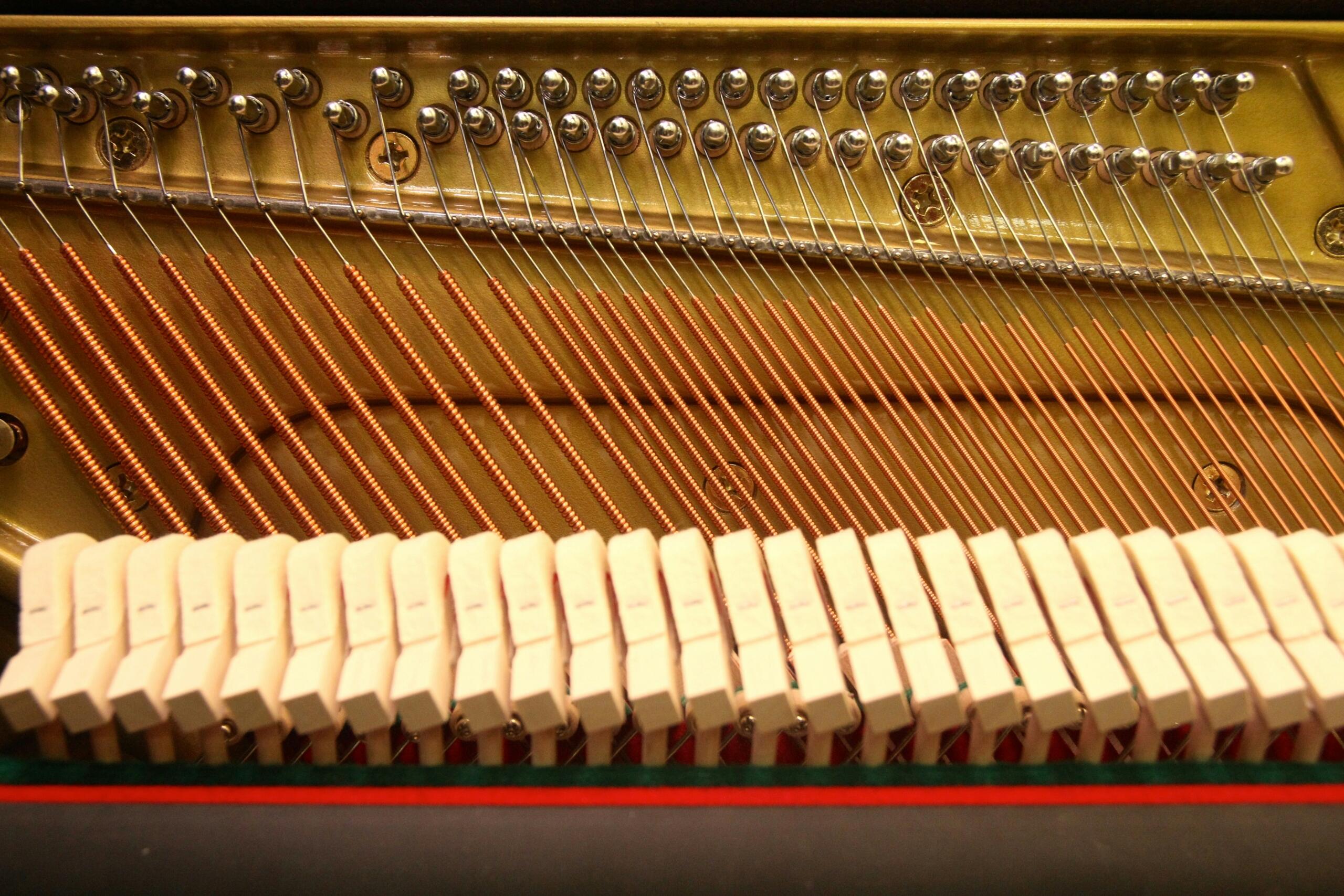 Close-up van de snaren en hamers aan de binnenkant van een piano.