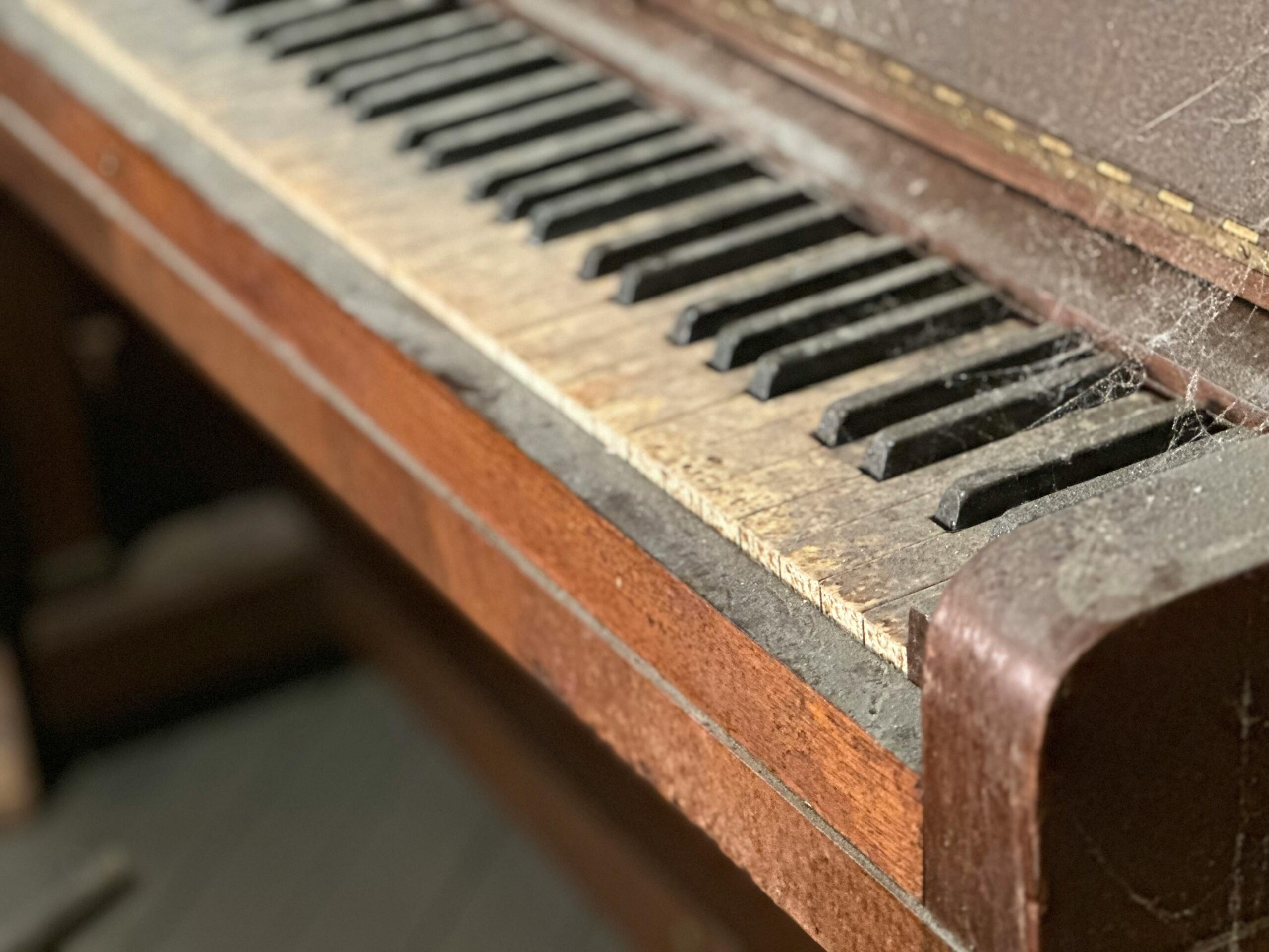 Vierkante close-up van een houten akoestische piano met zicht op de toetsen en kast.