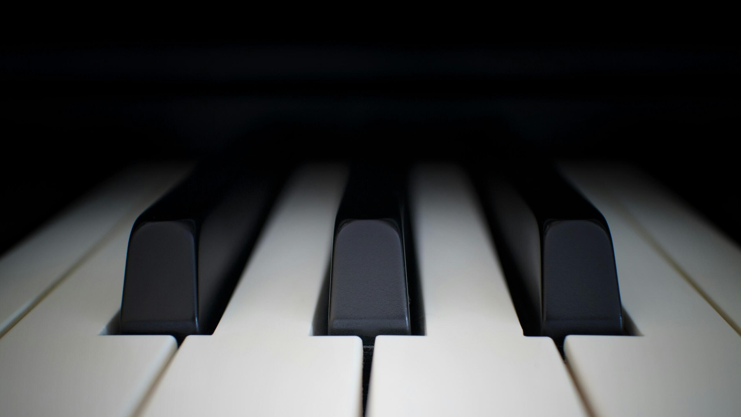 Close-up van pianotoetsen tegen een donkere achtergrond, met de toetsen scherp in beeld.