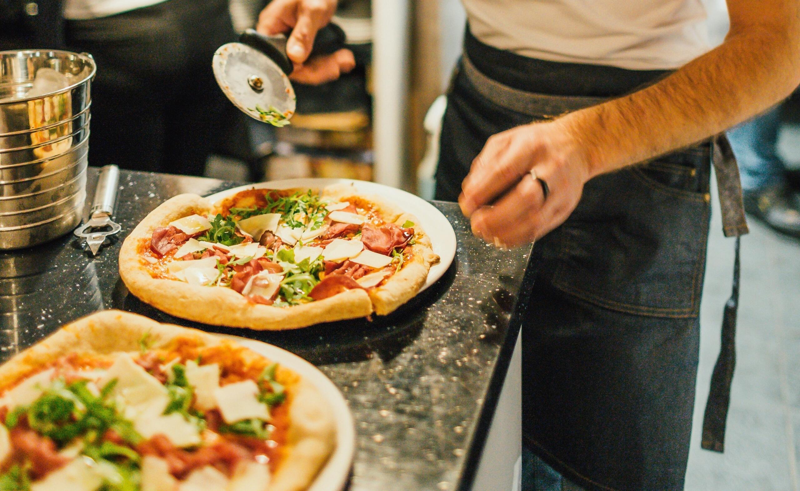 Pizza’s worden voorbereid op een werkblad tijdens het koken | Bron: Benu Marinescu, via Unsplash