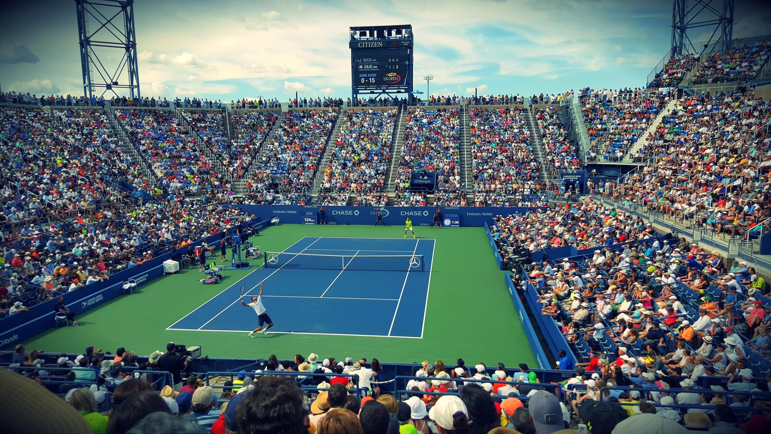 Tennisser serveert tijdens een wedstrijd op een blauwe hardcourtbaan in een vol stadion | Bron: Raj Tatavarthy, via Pexels