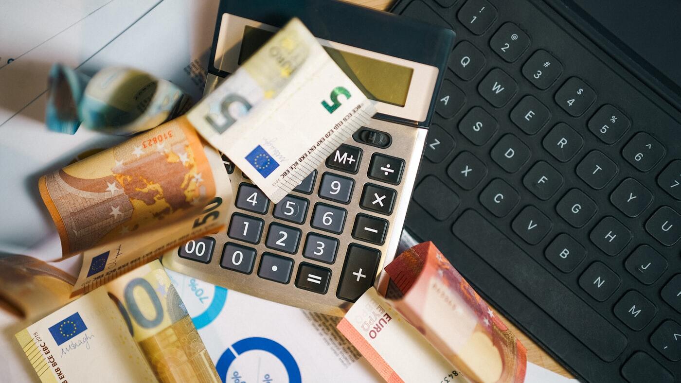 Een rekenmachine ligt op een stapel eurobankbiljetten.