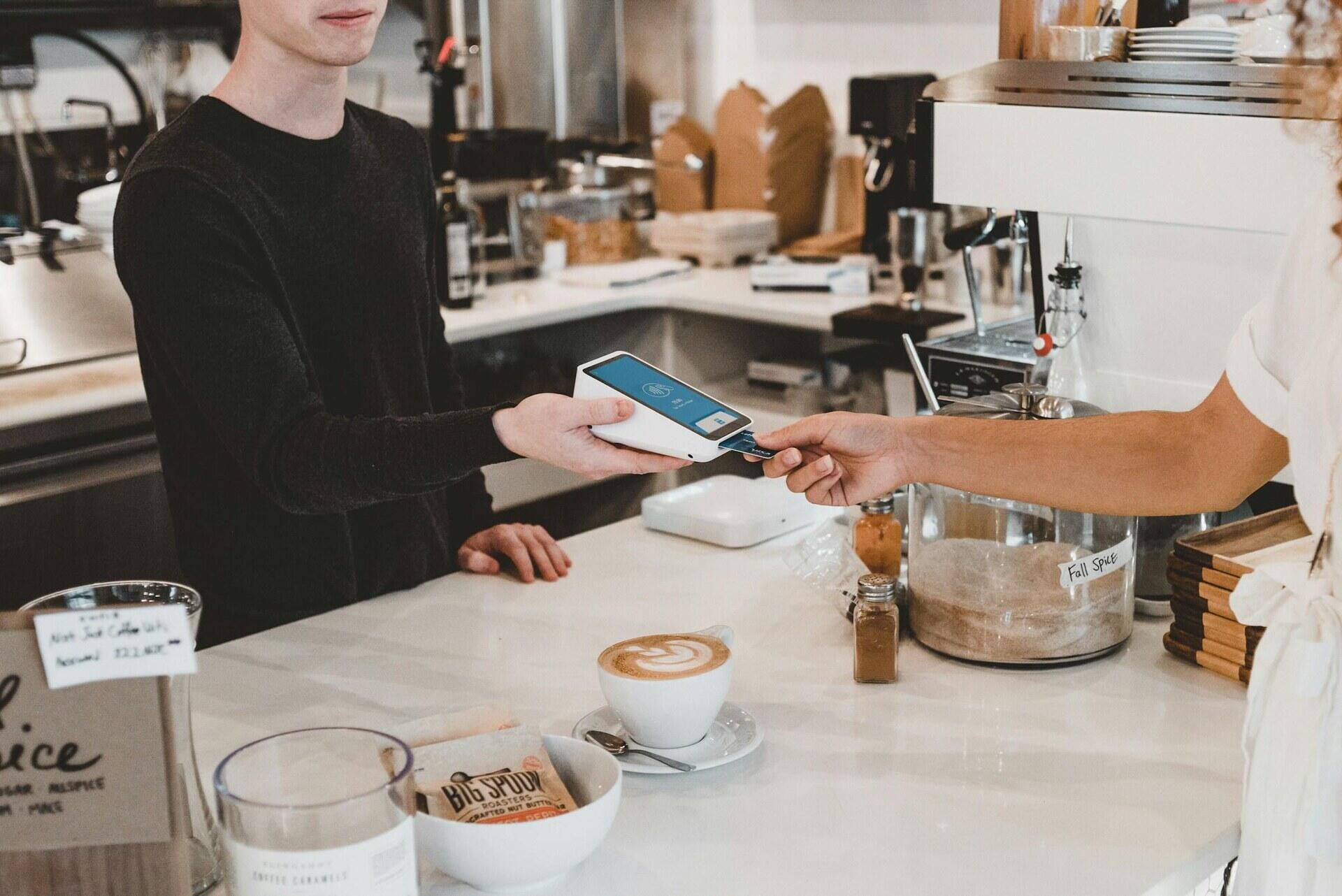 Klant betaalt contactloos met een kaart in een café