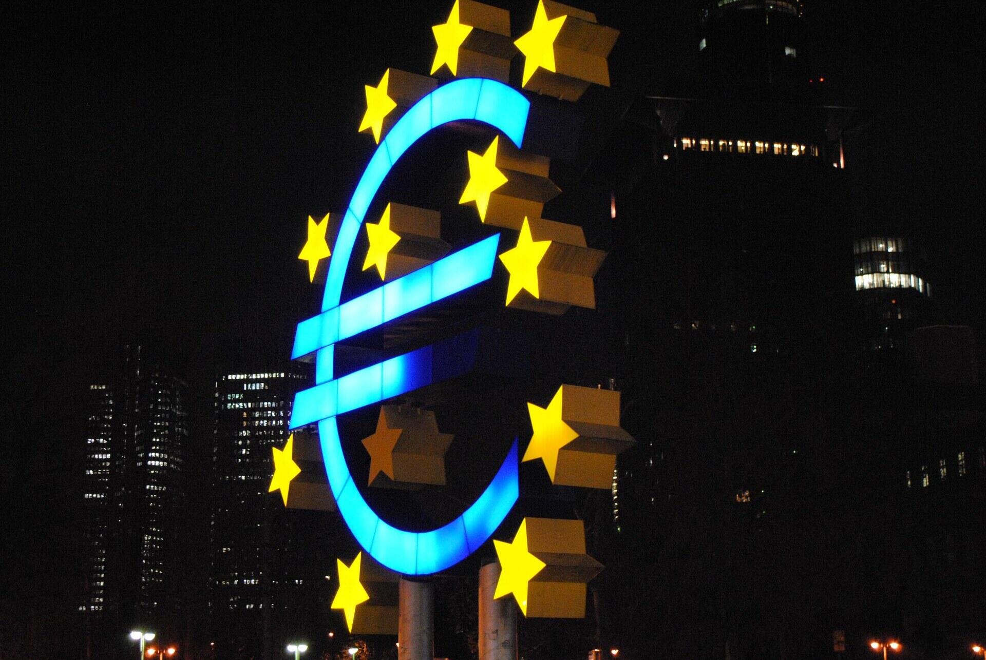 Verlicht eurosymbool met Europese sterren in het donker