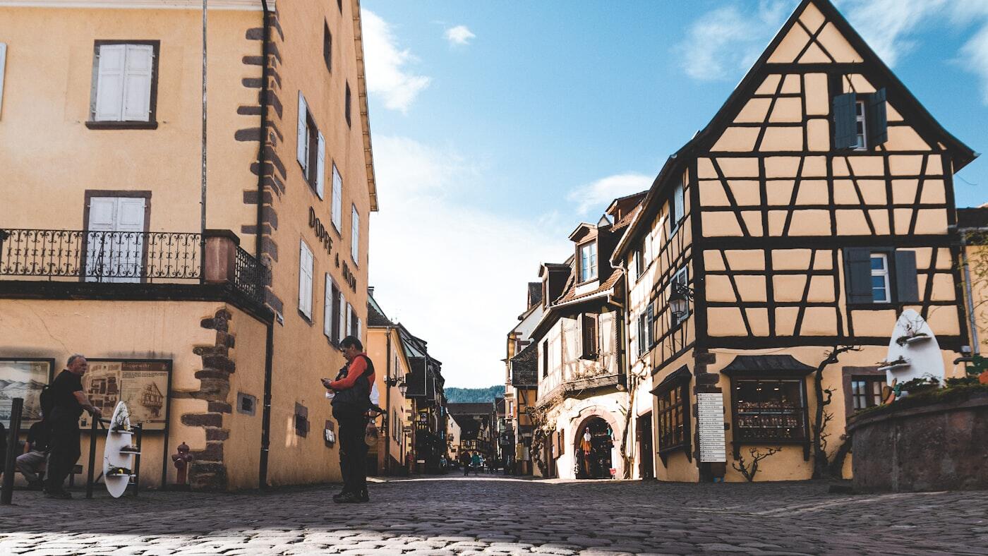 Een straat met vakwerkhuizen loopt door het Franse Riquewihr.