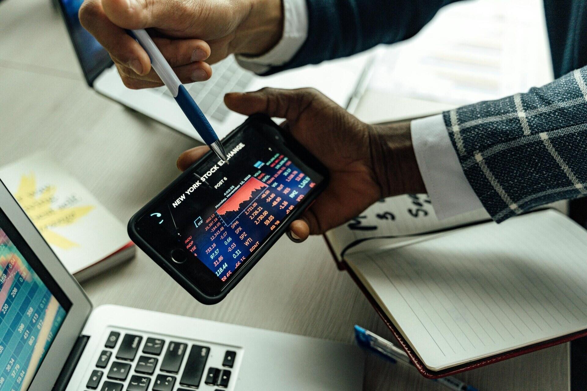 Twee personen bekijken cryptokoersen op een smartphone