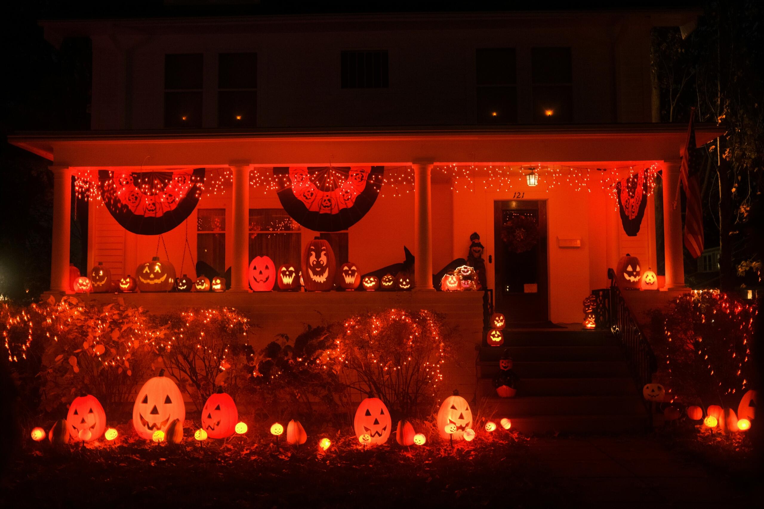 Woonhuis versierd met verlichte pompoenen en Halloweenverlichting