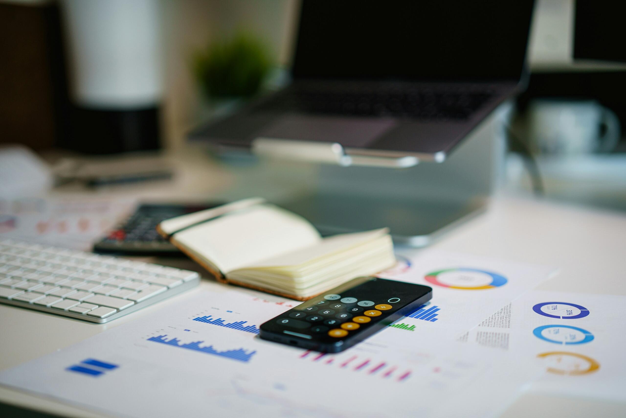 Bureau met calculator en financiële grafieken