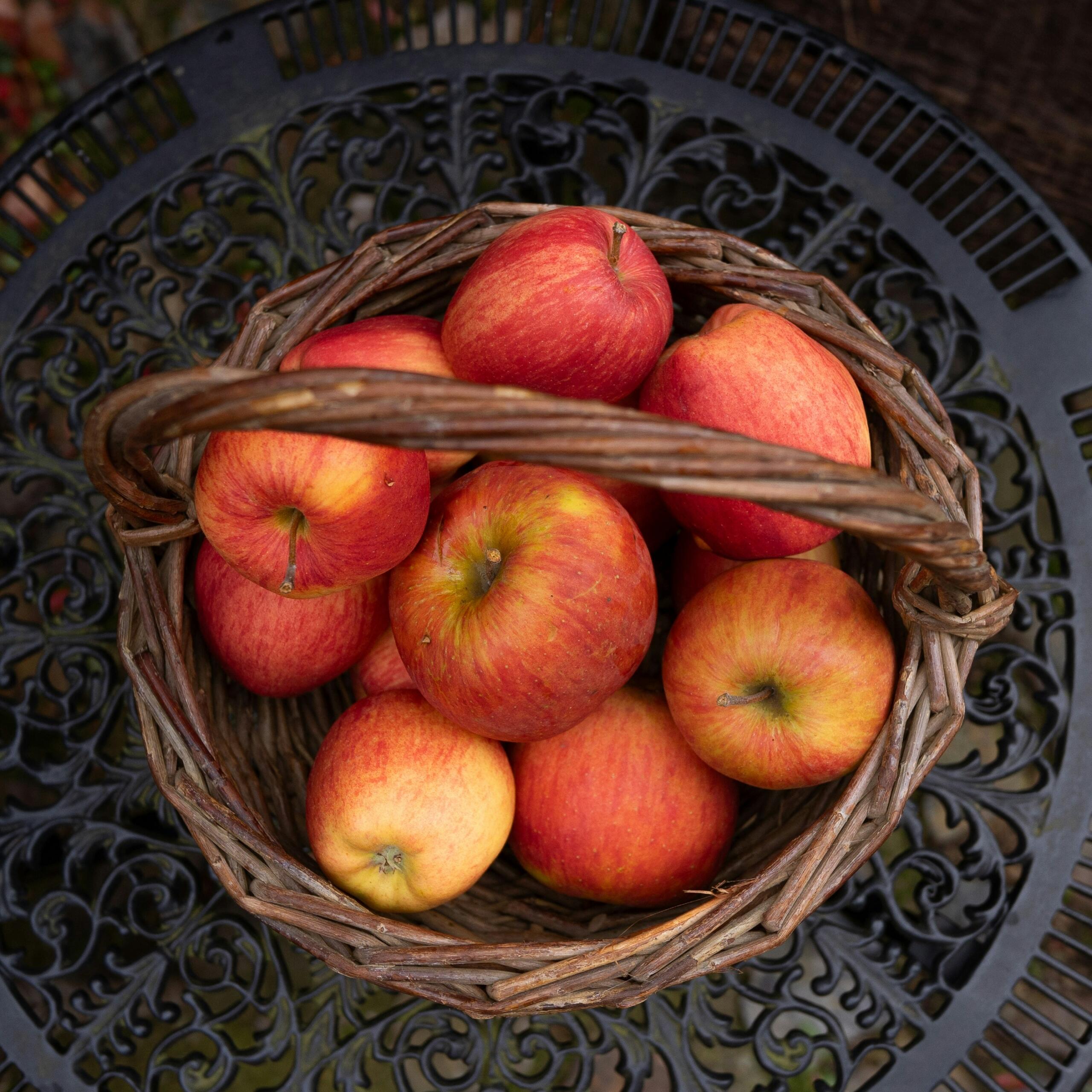 Mand met rode appels op een tafel