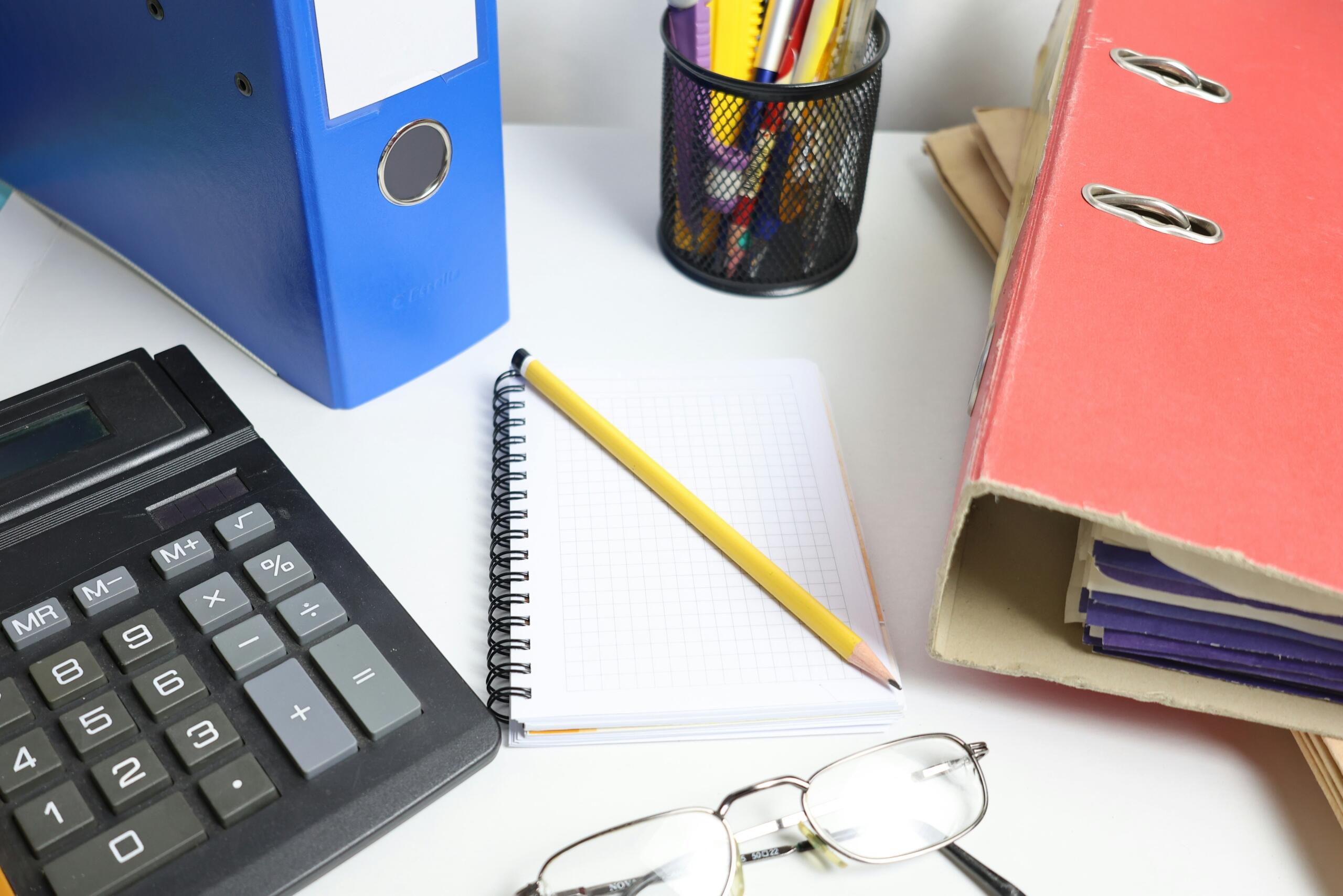 Calculator en notitieboek op een bureau