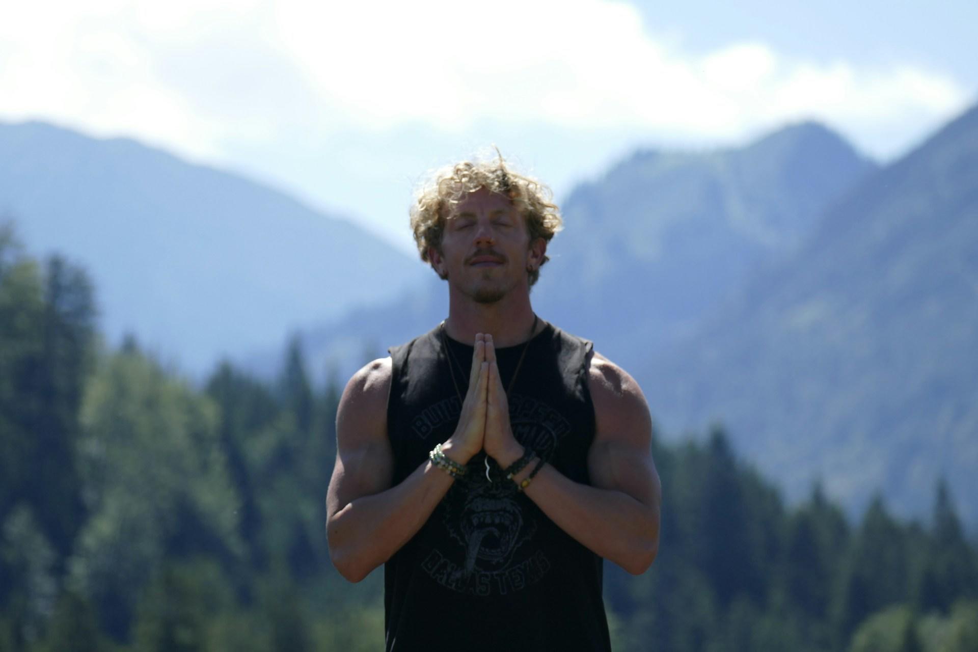 Mann står i fjellposisjon yoga