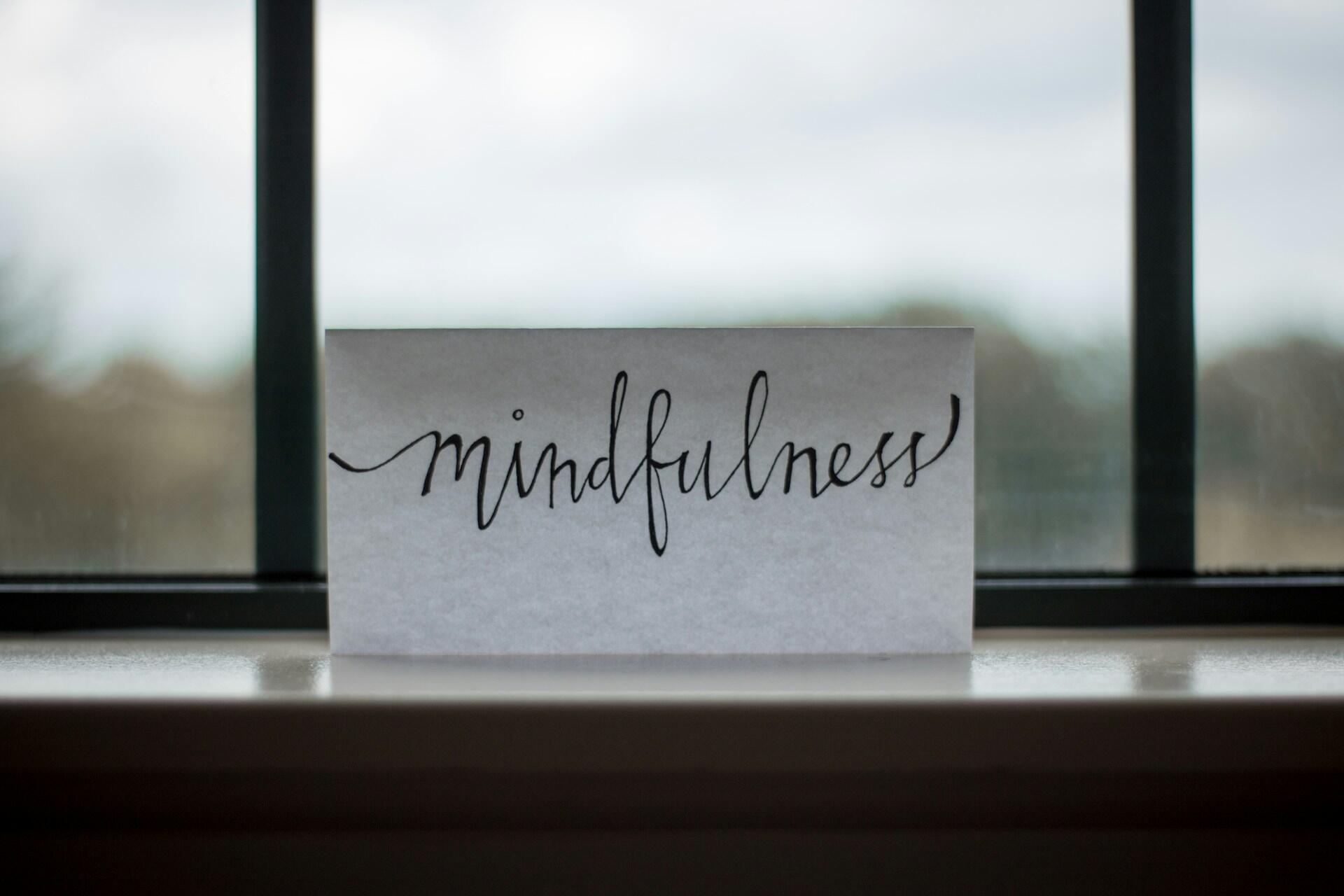 Mindfulness skrevet på ark i vinduskarmen