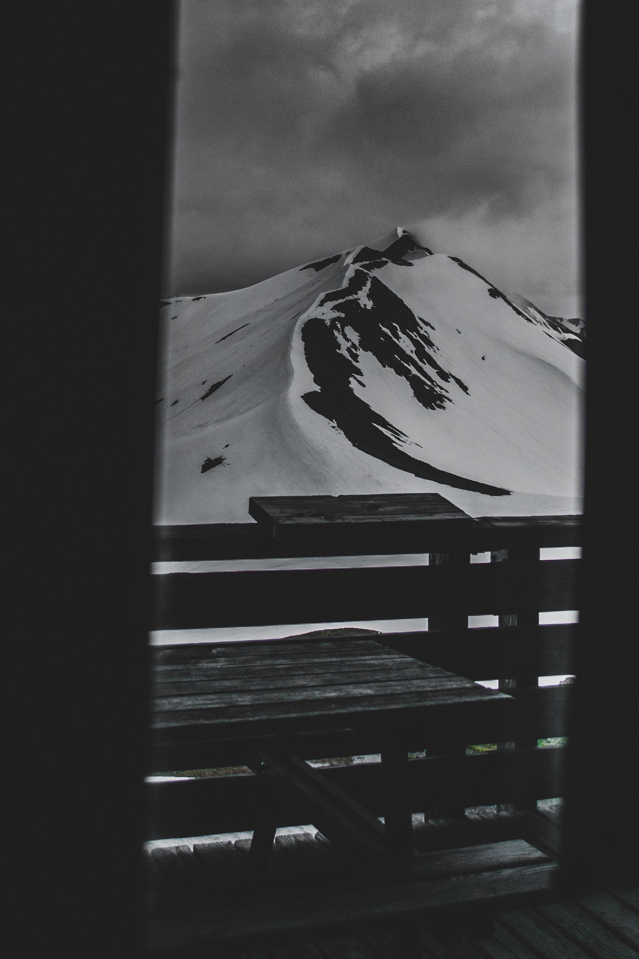 Et bilde av snødekte fjell er tatt gjennom en dør
