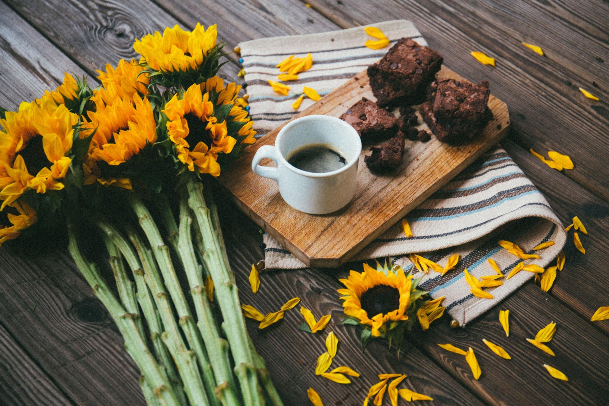 Brownies, kaffe og solsikker på trebrett