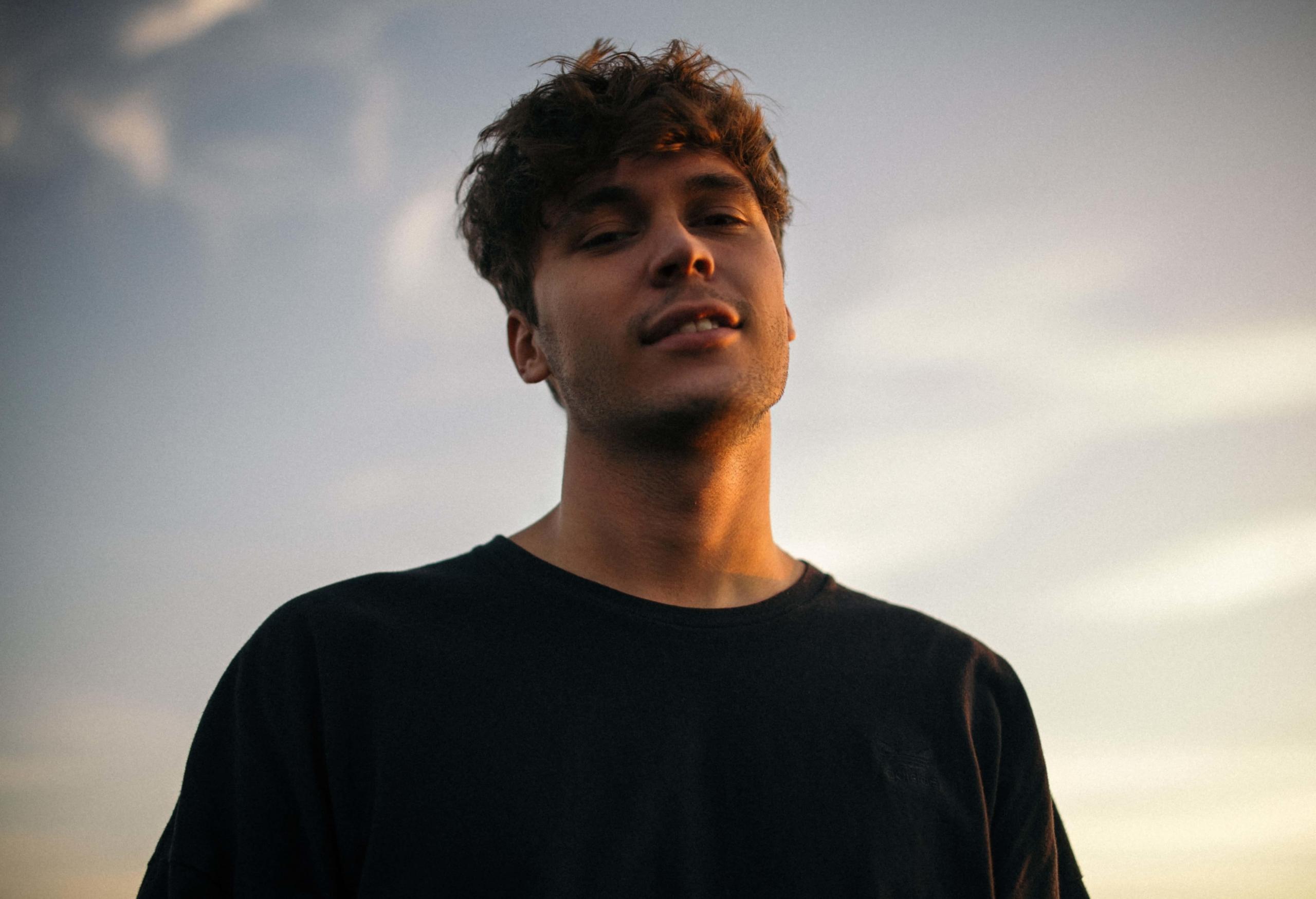 Mann i solnedgang smiler ned til kamera