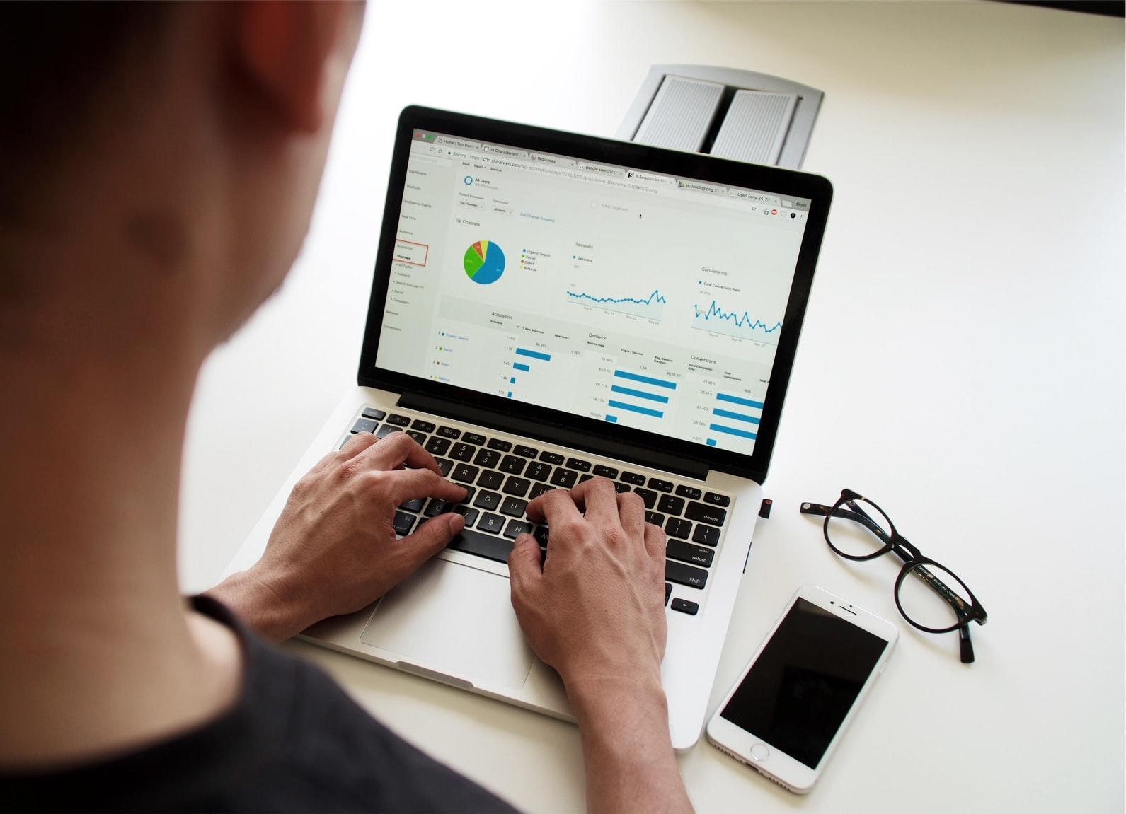 En person som sitter foran en PC med statistikk på skjermen