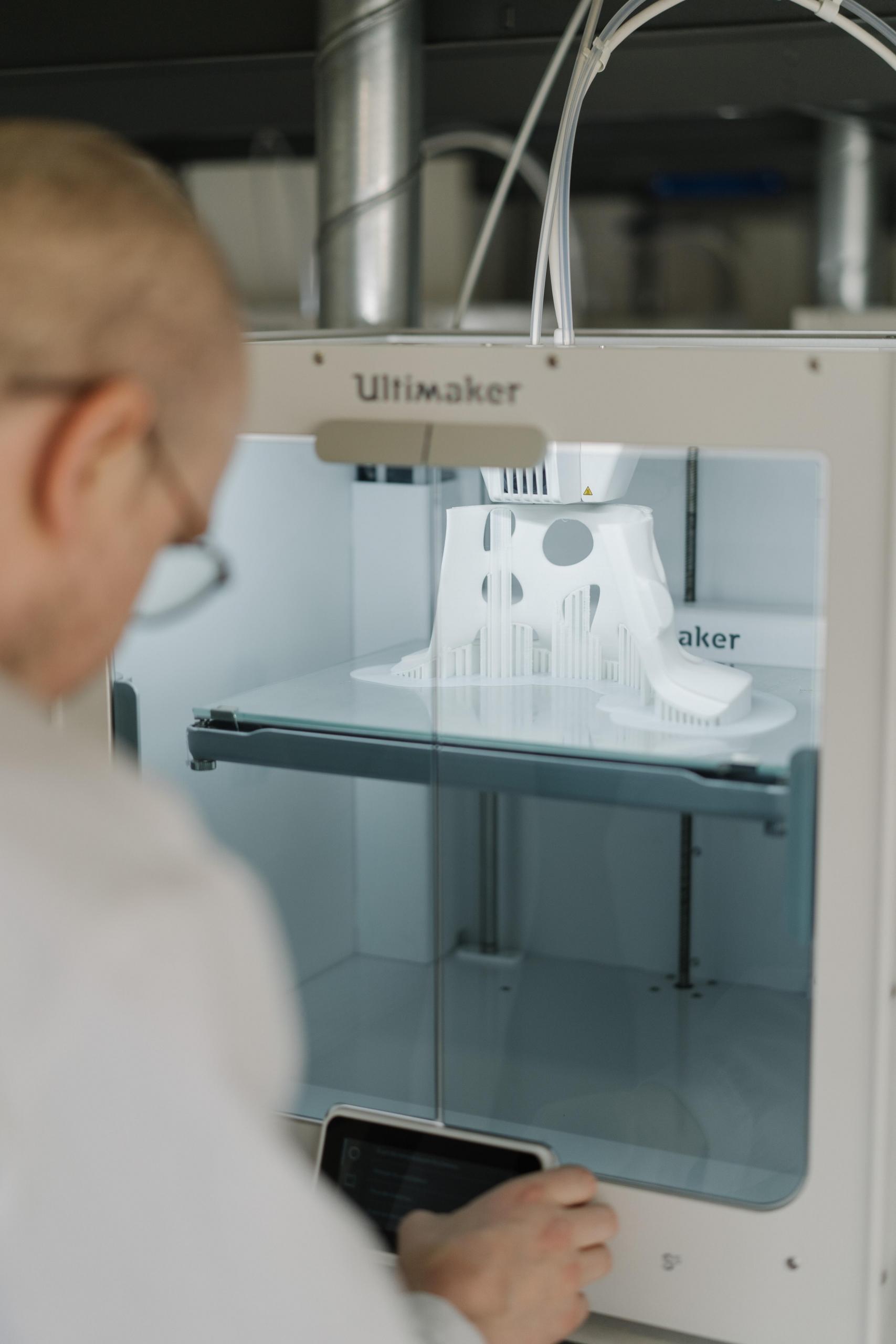 Mann står foran en 3D-printer