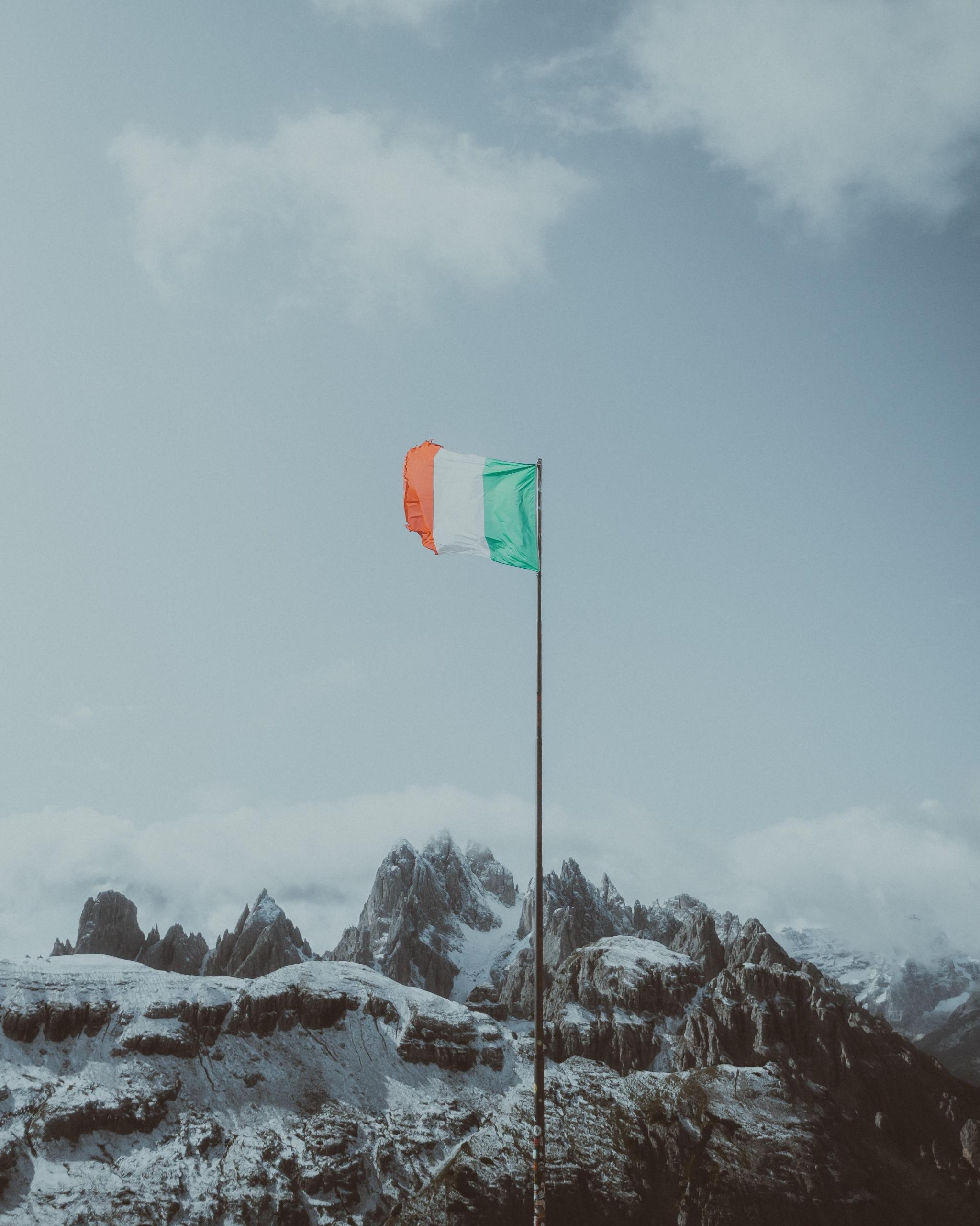 bilde av italienske fjell, snø og blå himmel og et flagg