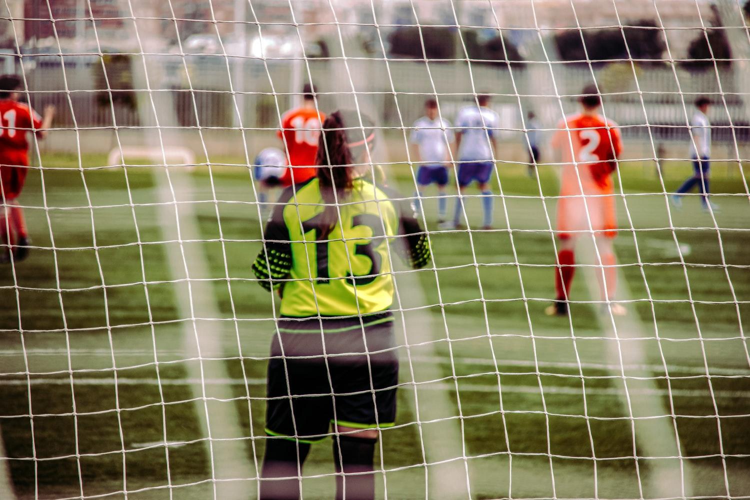 En jente på fotballbanen med tallet 13 på ryggen