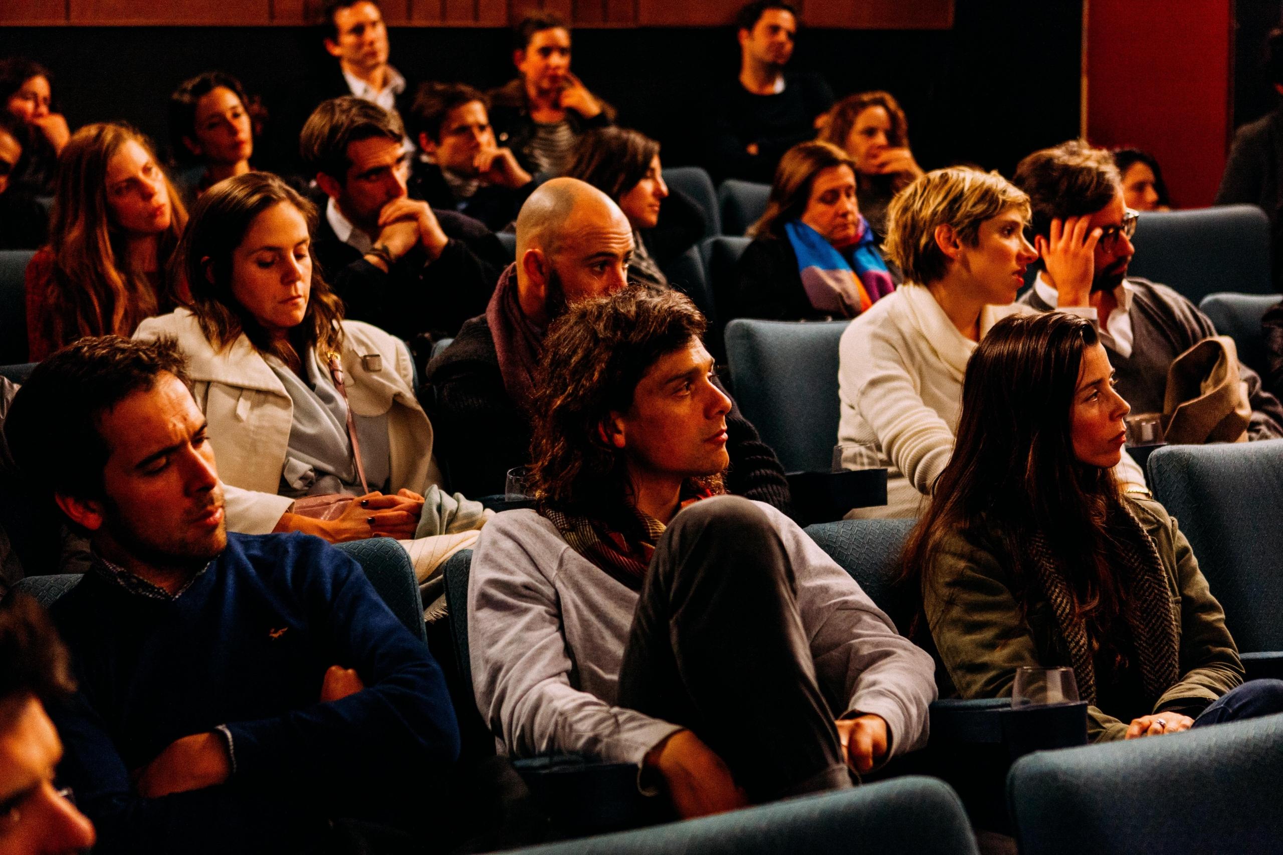 et lite auditorium med en del seter fylt opp av relativt unge voksne