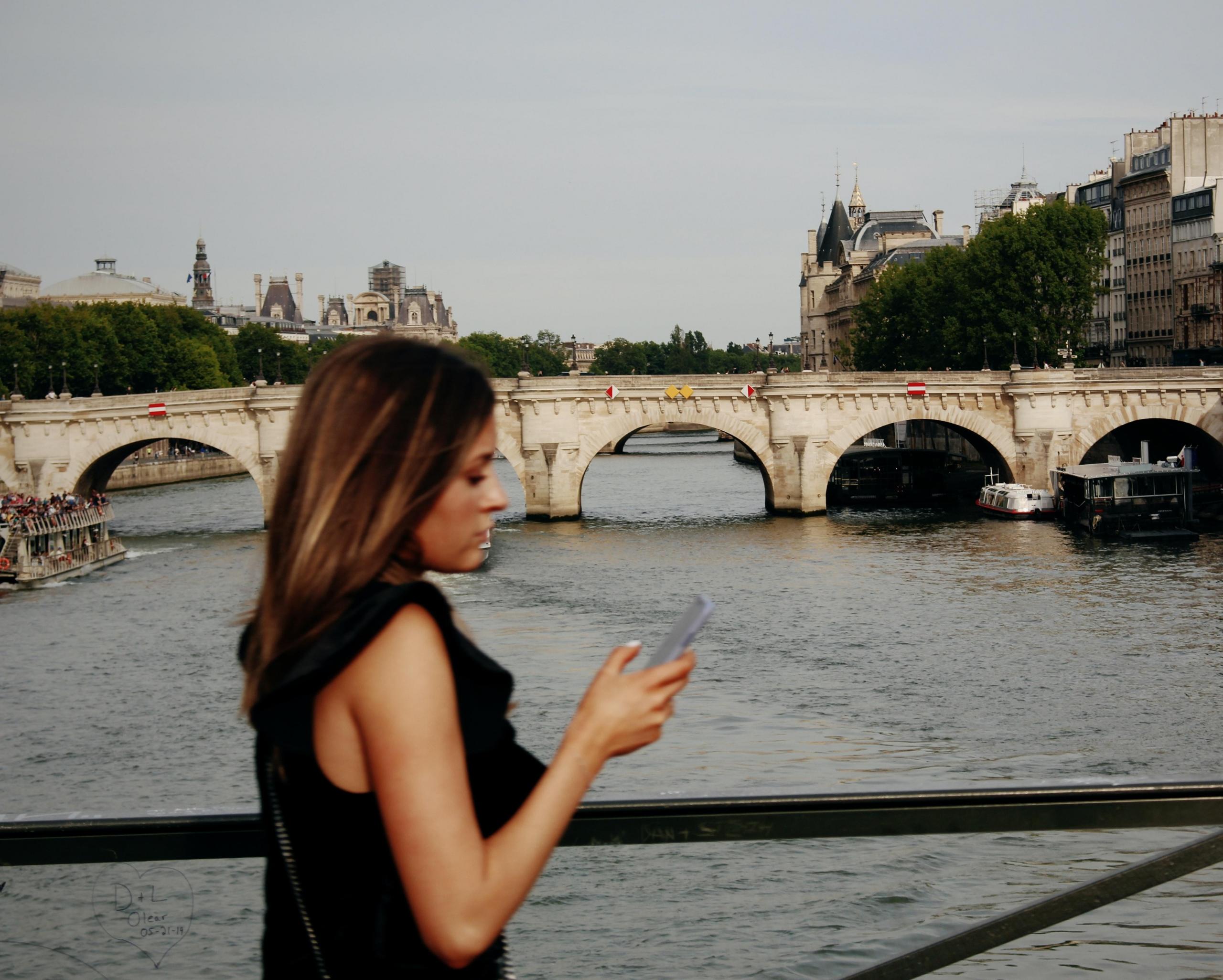 En pyntet dame krysser en bro over Seinen i Paris.
