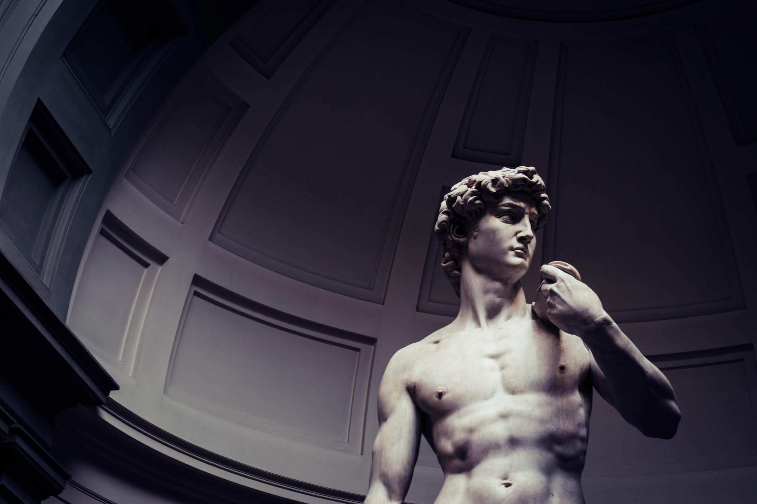 En marmorskulptur av en naken, muskuløs mann.