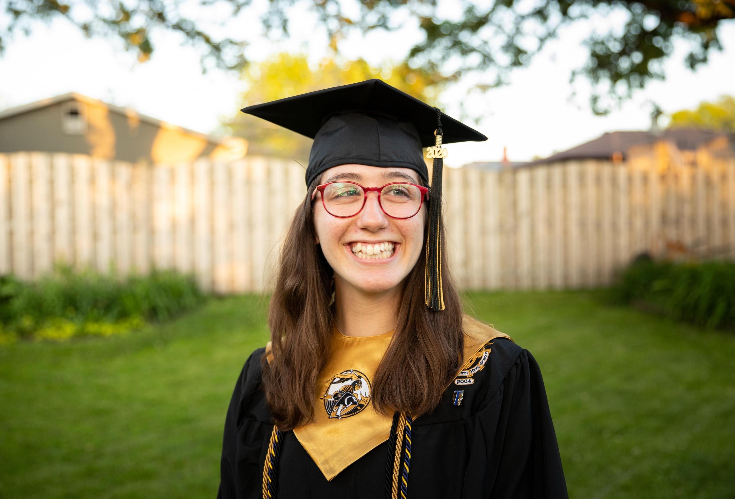 portrett av en jente med et bredt smil og graduation-hatt og -kappe