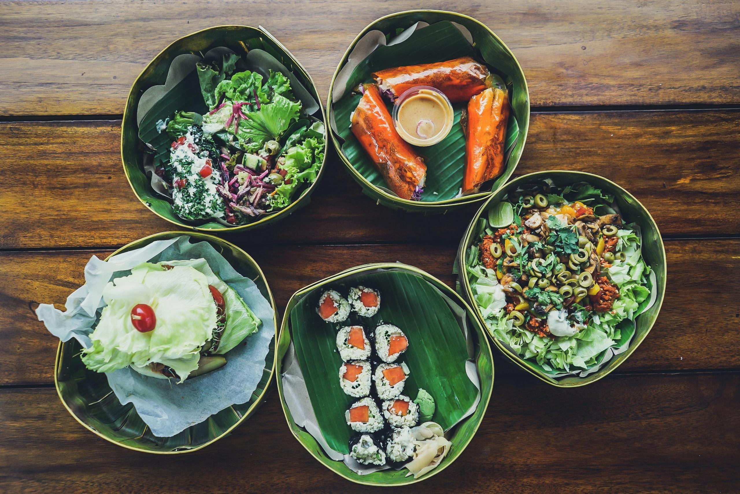 fem boller fotografert ovenfra med forskjellige retter i, salat, sushi, noen ruller