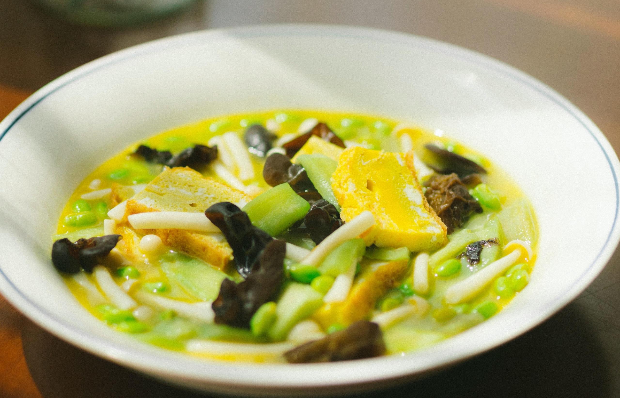 fargesterk suppe med gule, grønne og brune ingredienser
