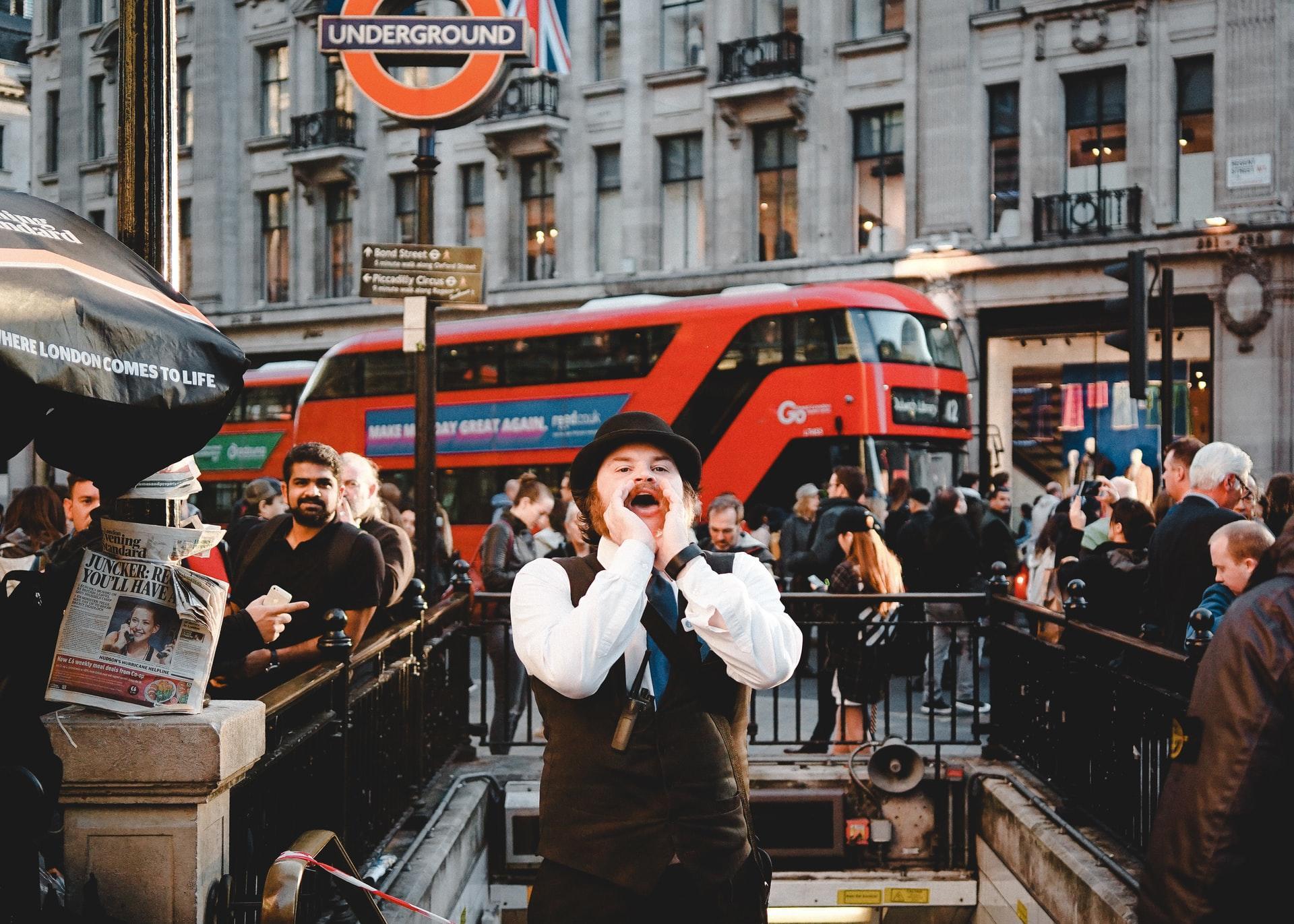 Mann roper ved undergrunnen i London