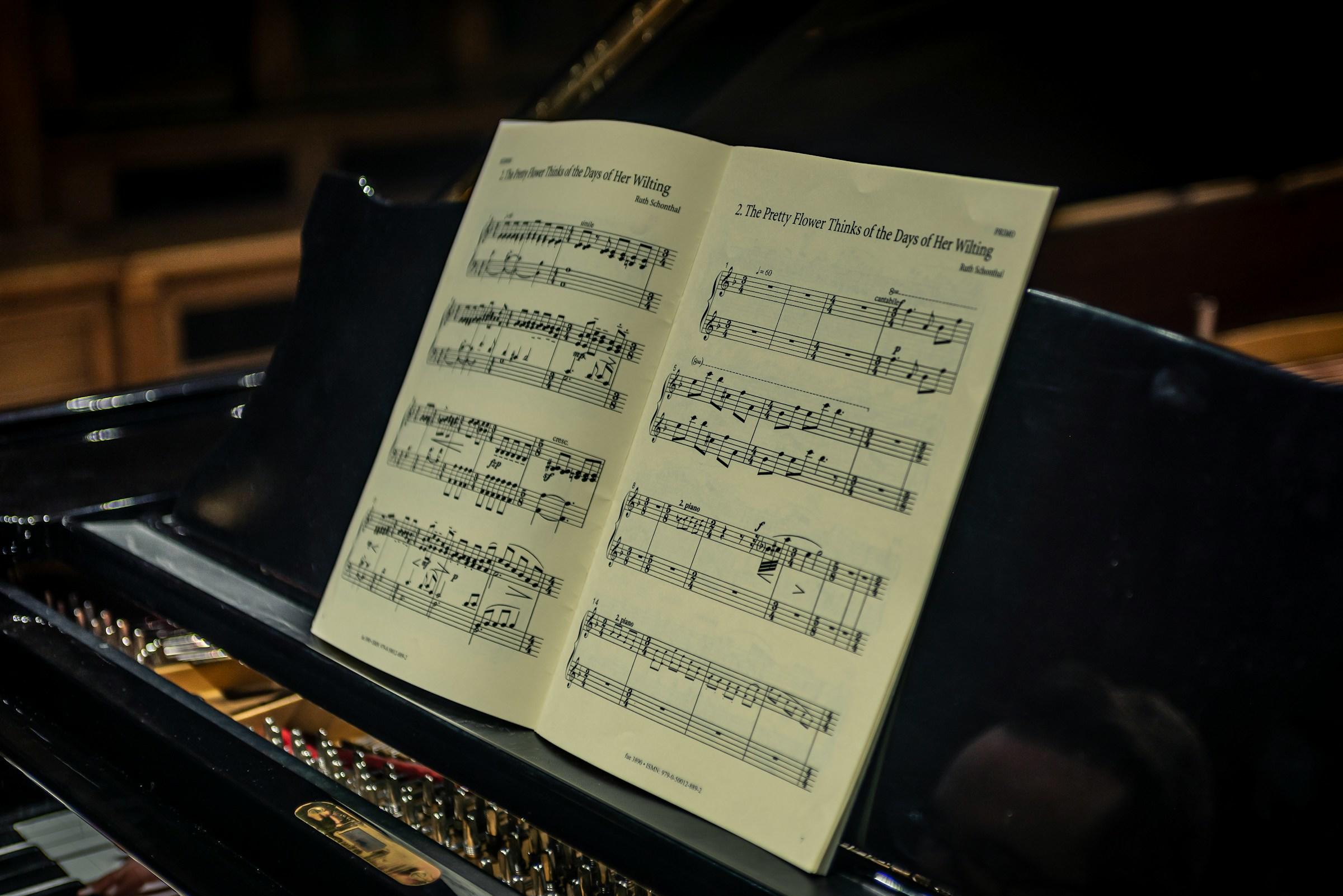 Et ark med pianonoter som står oppå et piano.